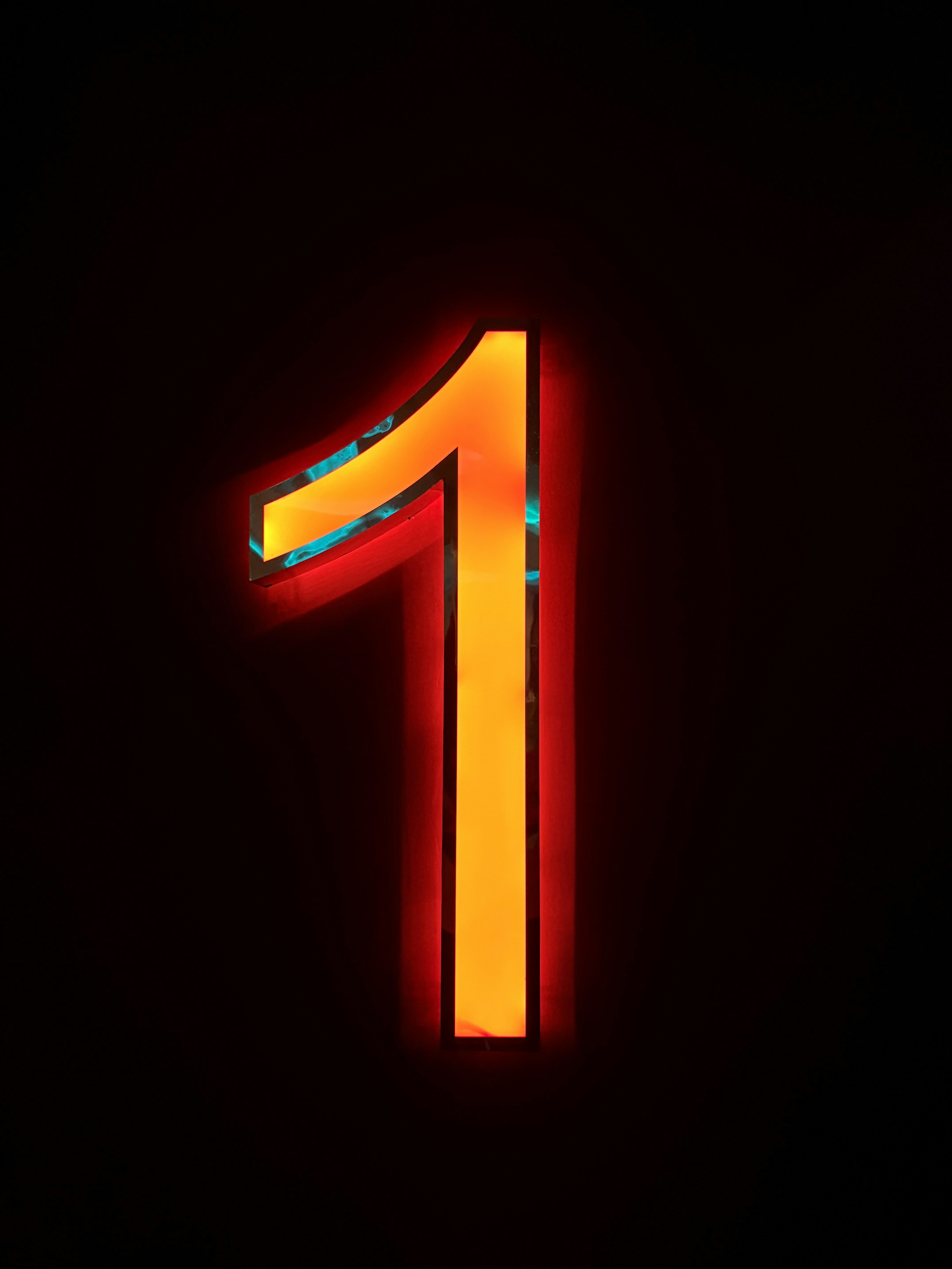 A glowing orange neon number one against a dark background