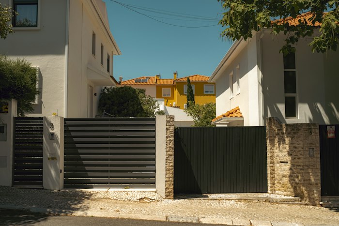 Portails sombres entre deux maisons blanches