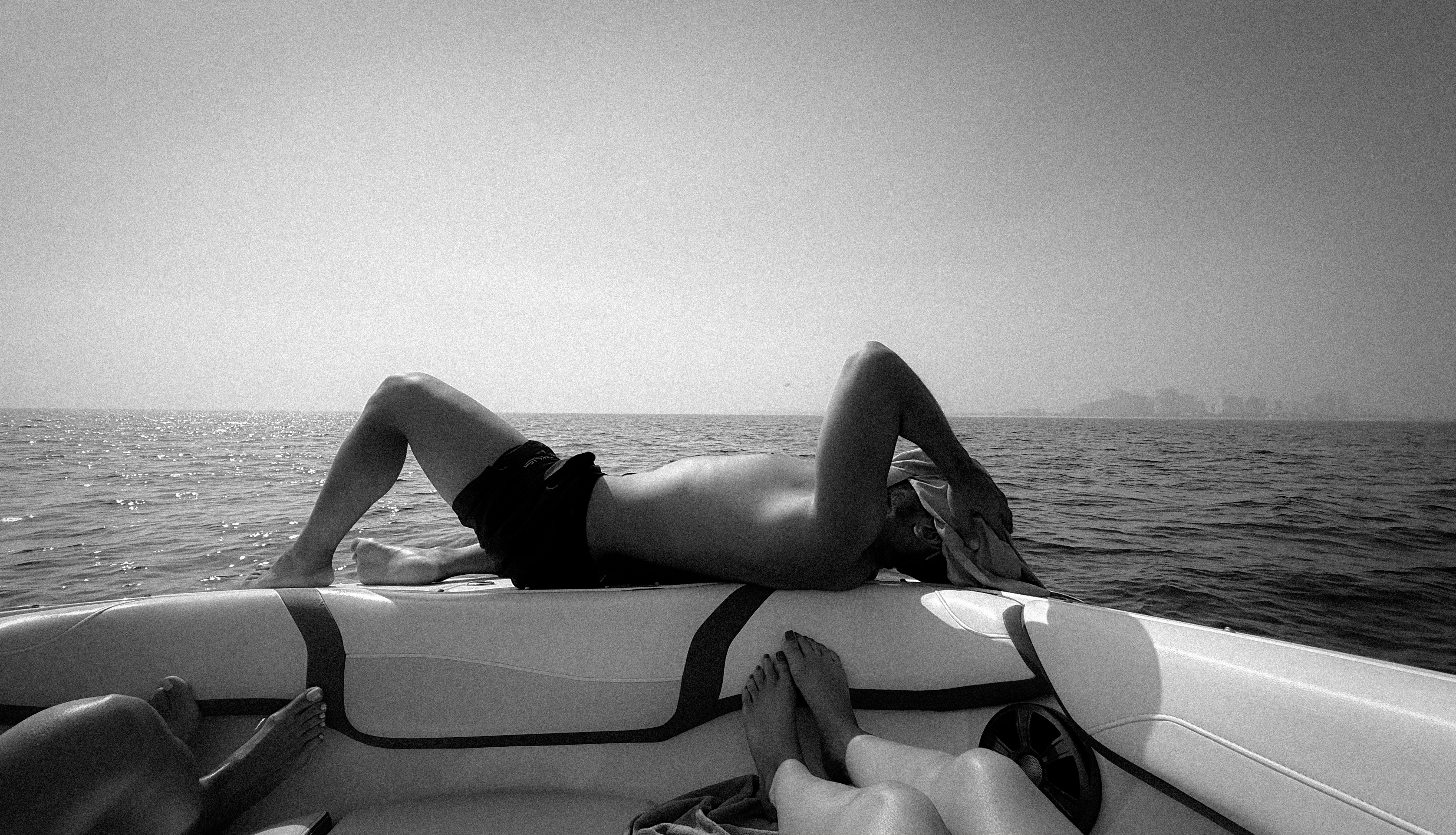 A person lying on the deck of a boat on the sea in Kish