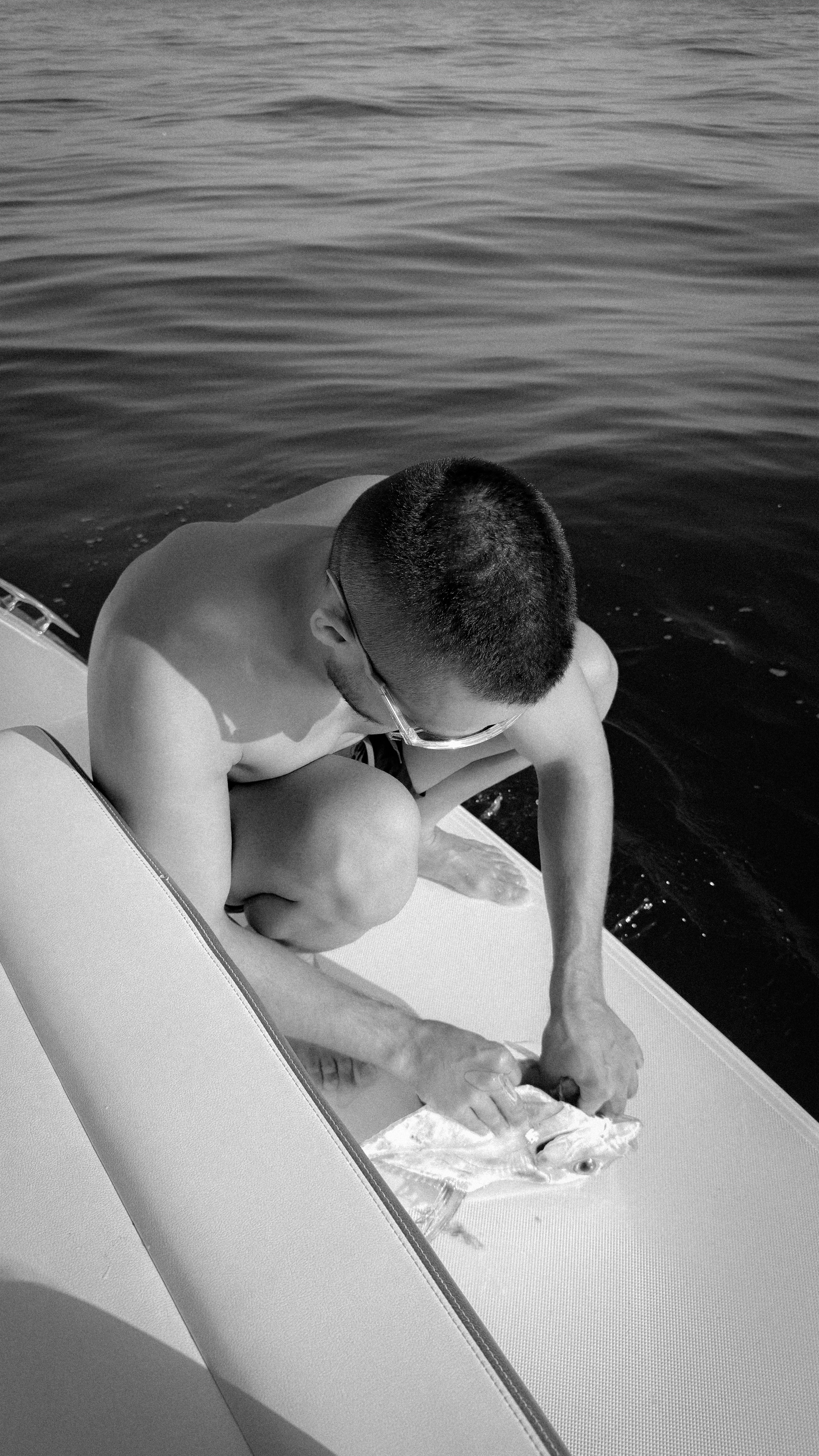 A person cleaning a fish on the deck of a boat