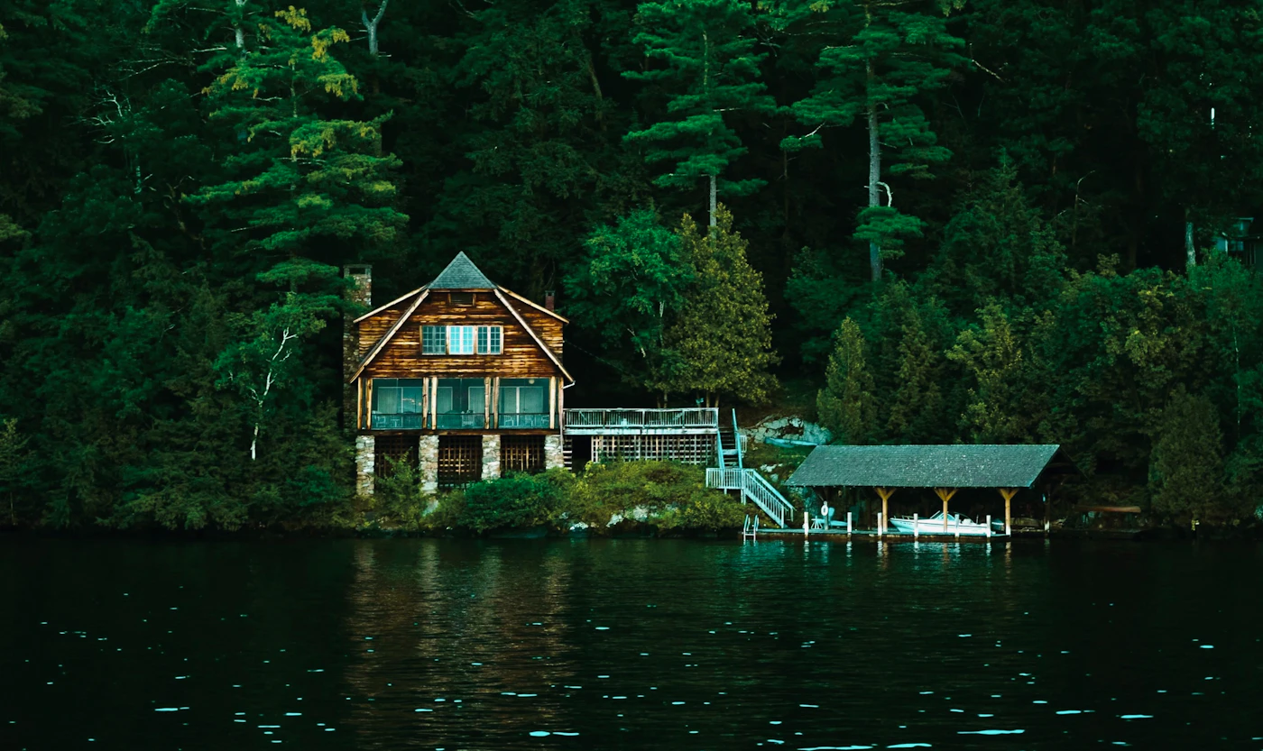 Lake house nestled in a green forest by the water