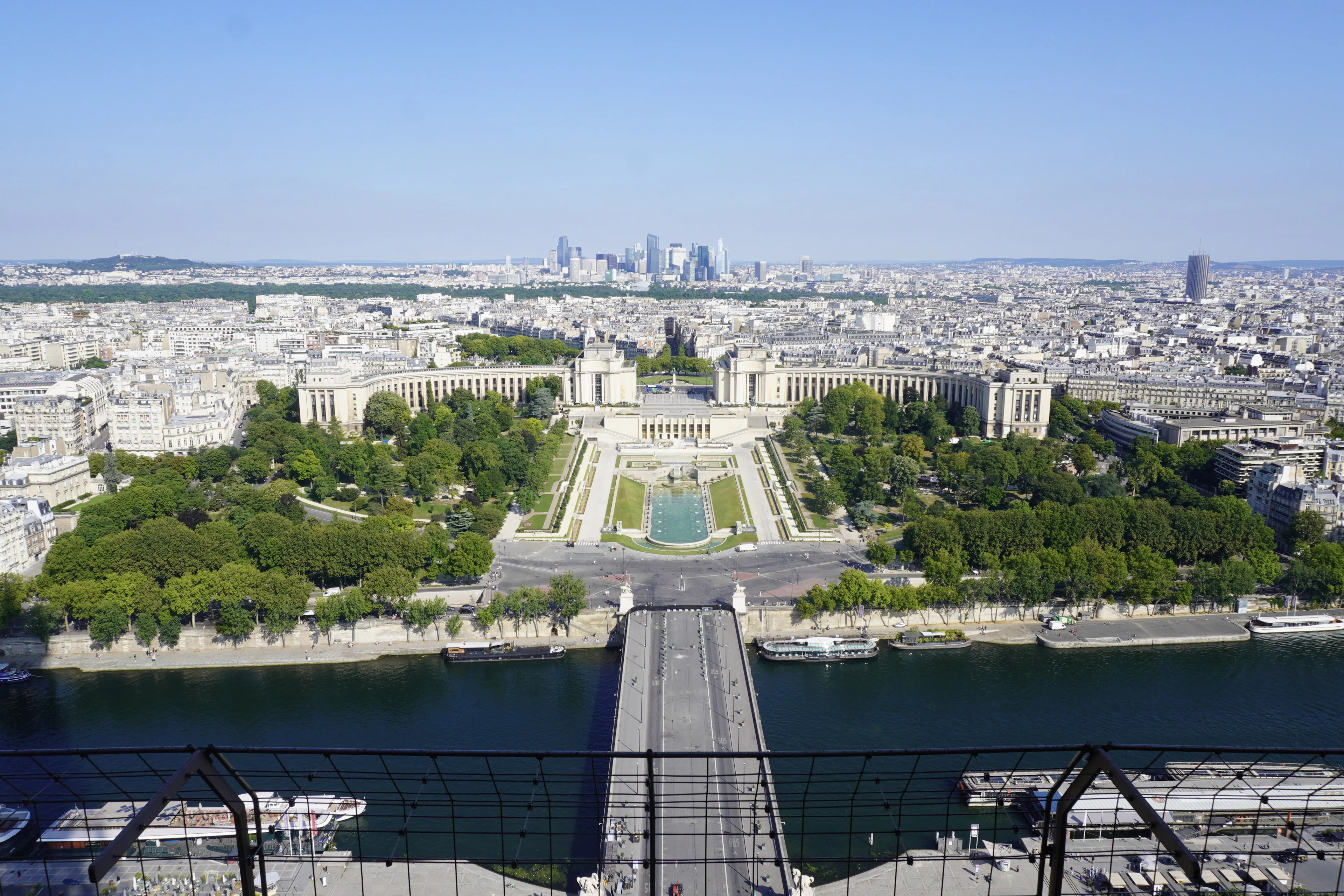 View from the Eiffel Tower through its safety mesh down to the Pont d'Iéna, the Trocadéro gardens and La Défense