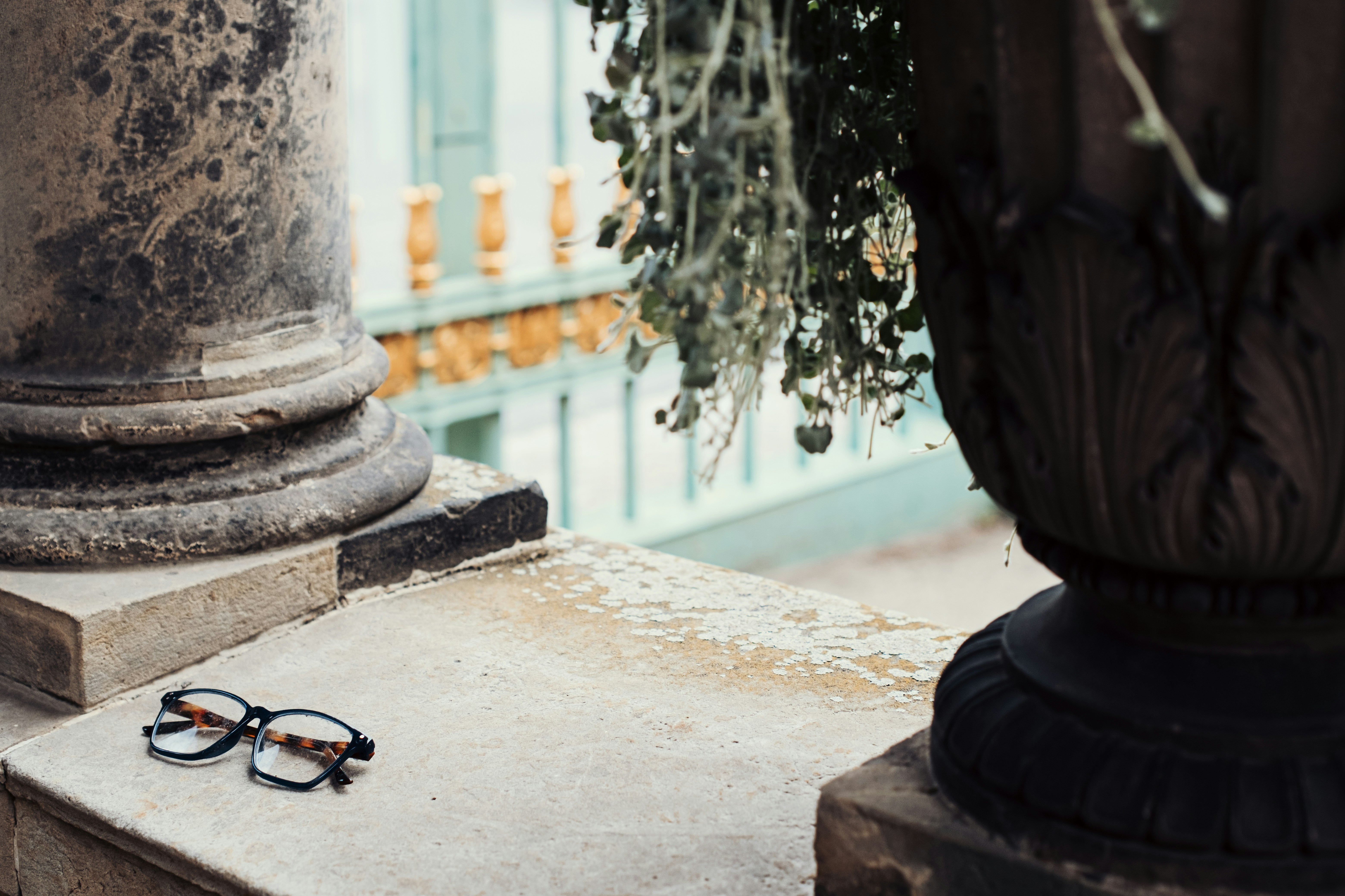 Tortoiseshell glasses on a stone ledge beside a classical column in Potsdam, Germany