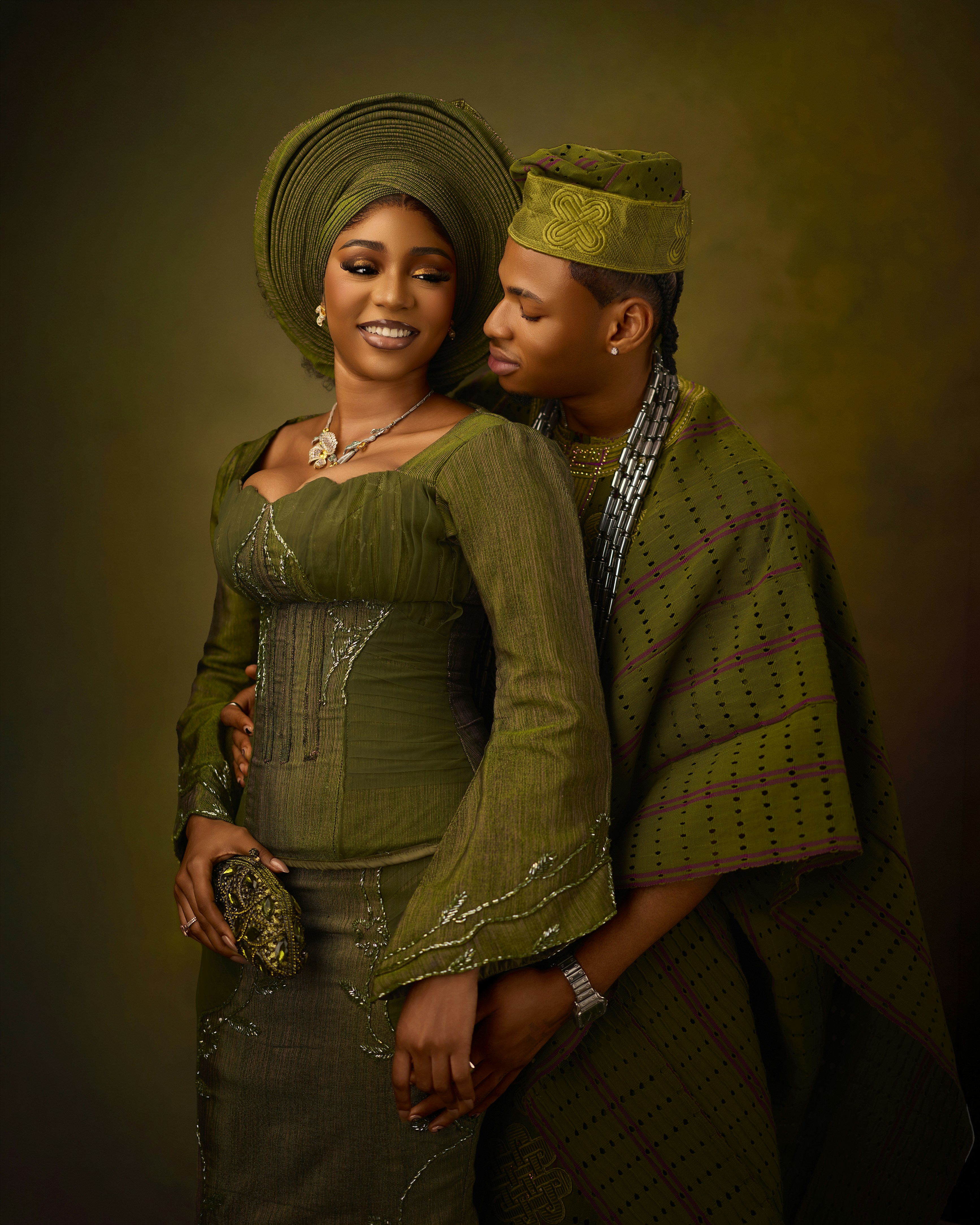 A woman and a man in traditional green Nigerian attire posing together