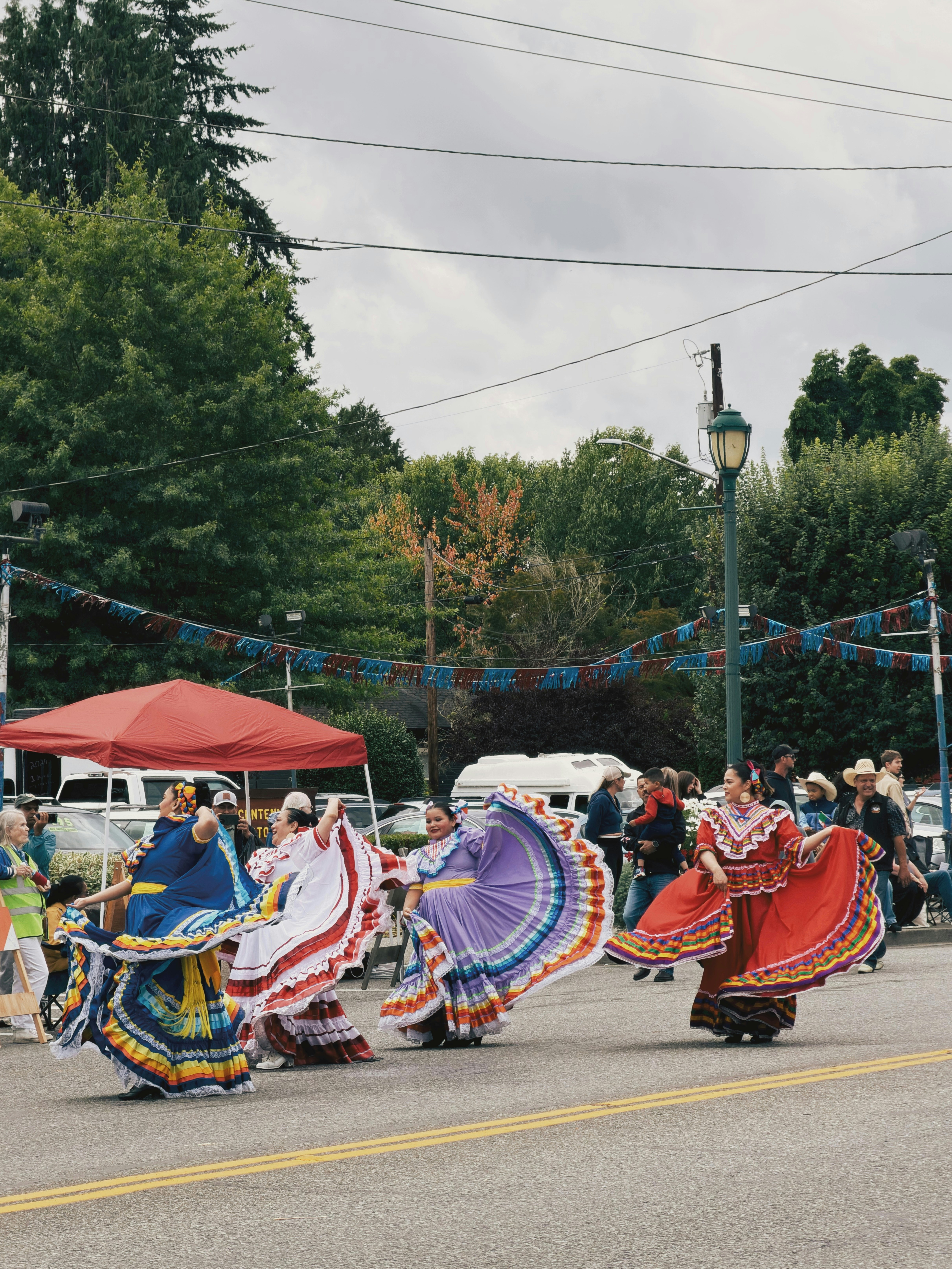 Mujeres con trajes tradicionales bailando durante una celebración latina