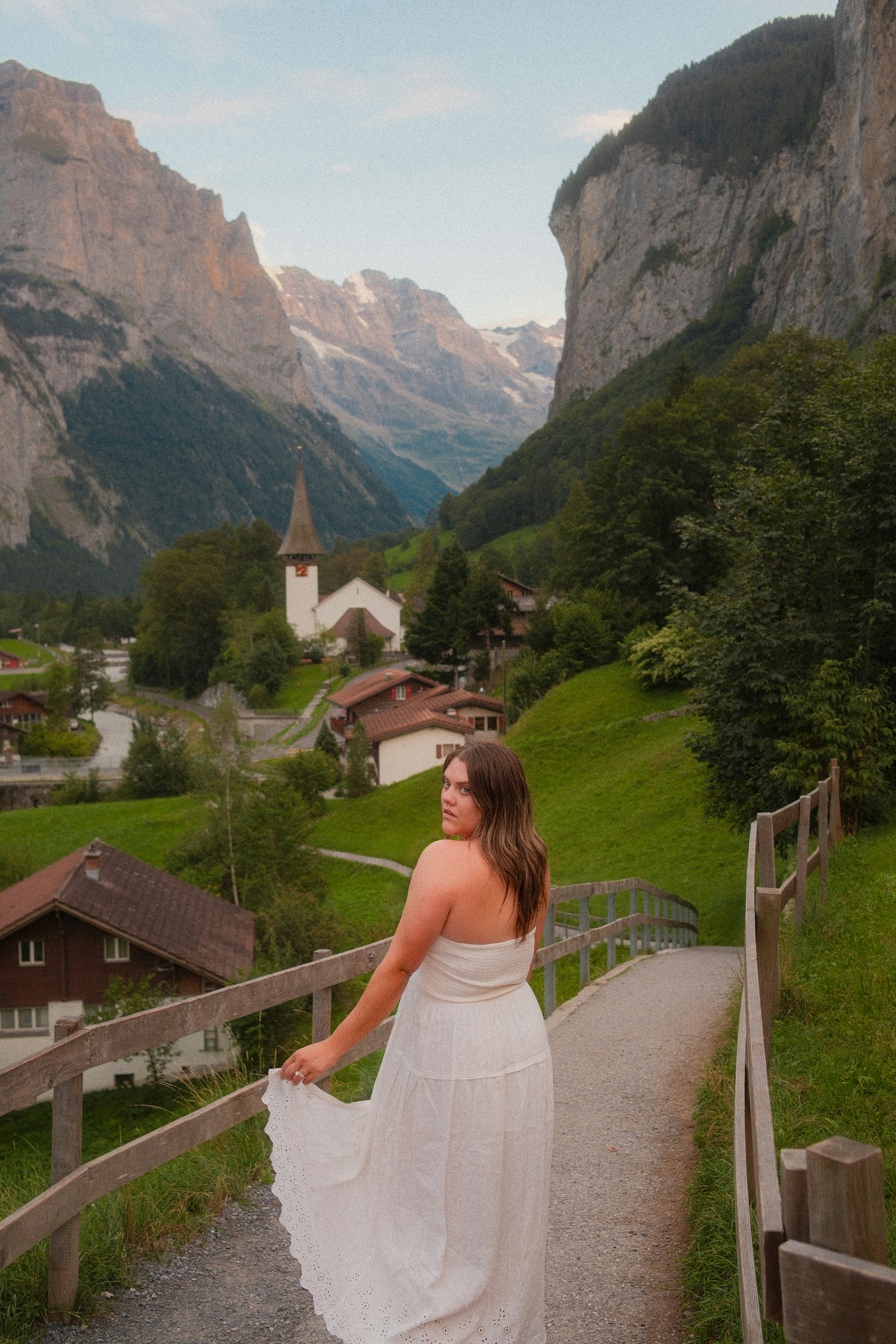 A woman in a white dress on a path in Lauterbrunnen, Switzerland