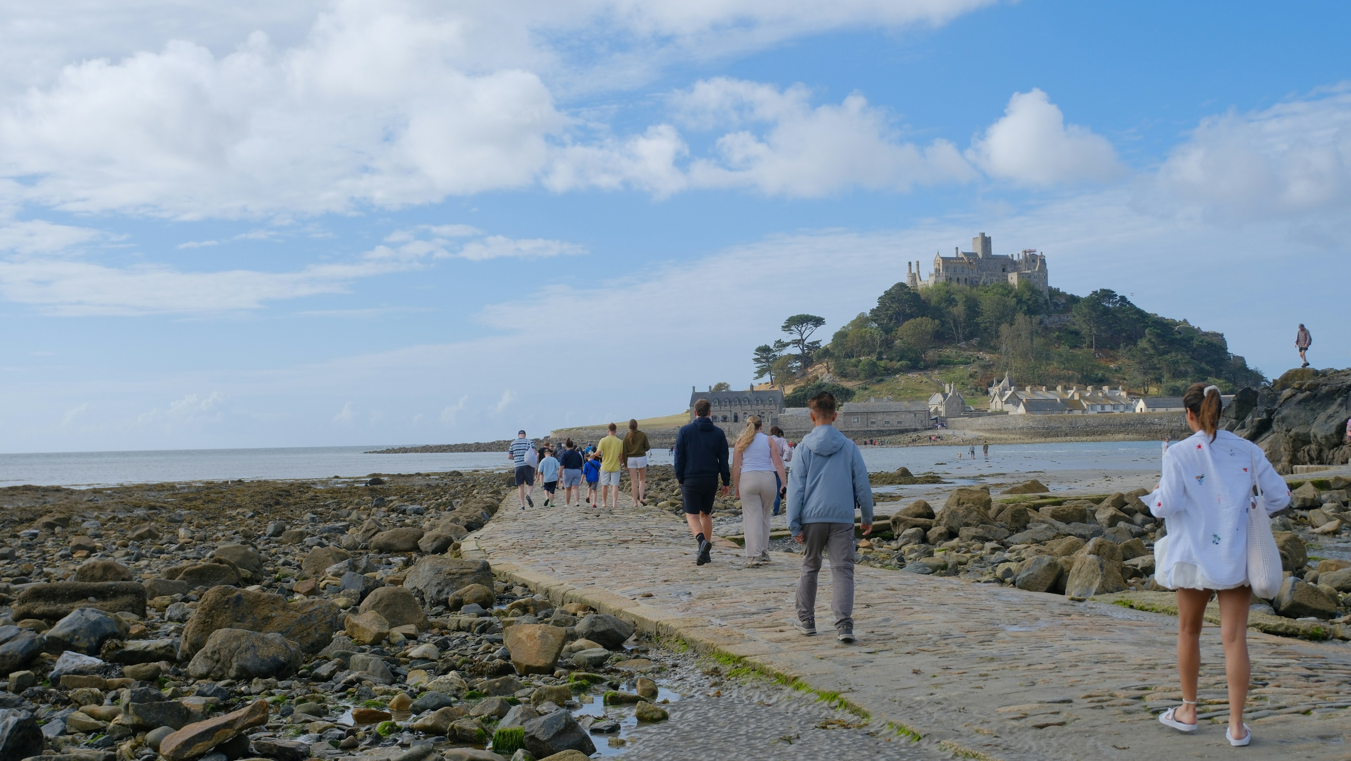 People walking along a stone causeway toward St Michael's Mount in Cornwall
