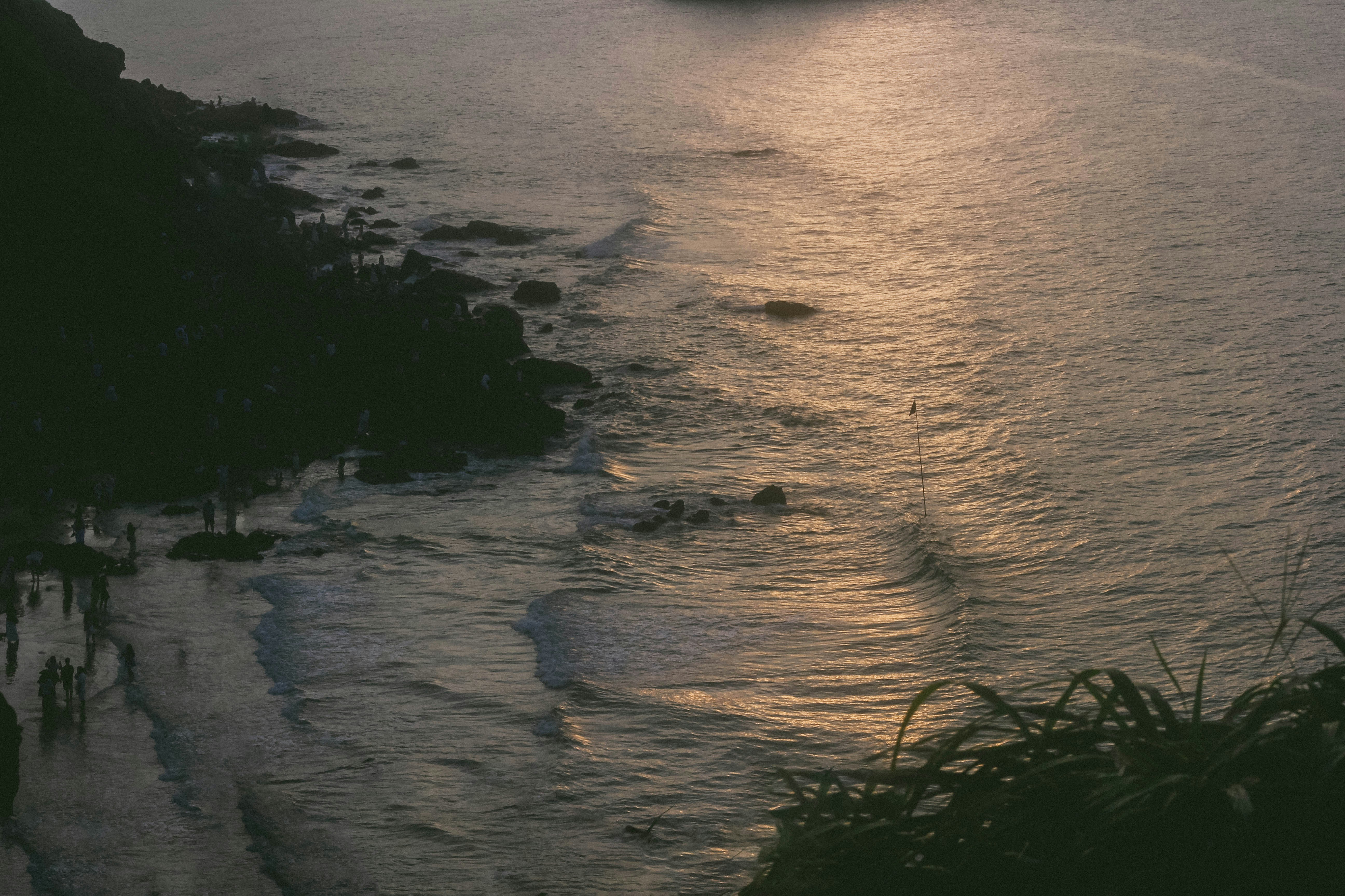 Gens sur la Plage Rocheuse en mer - Photo gratuite sur Unsplash