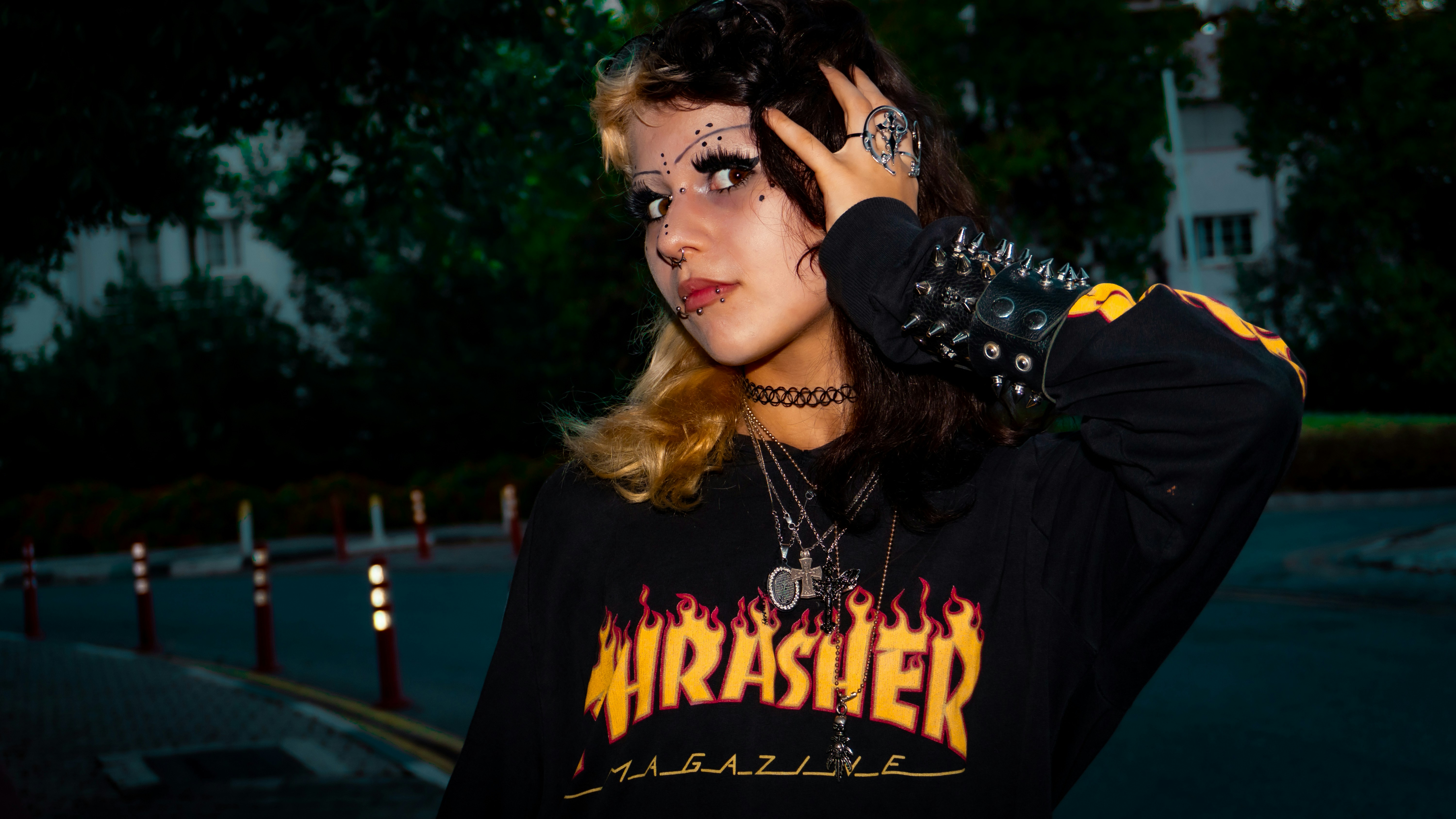 A person with two-toned hair and facial piercings wearing a black long-sleeved shirt
