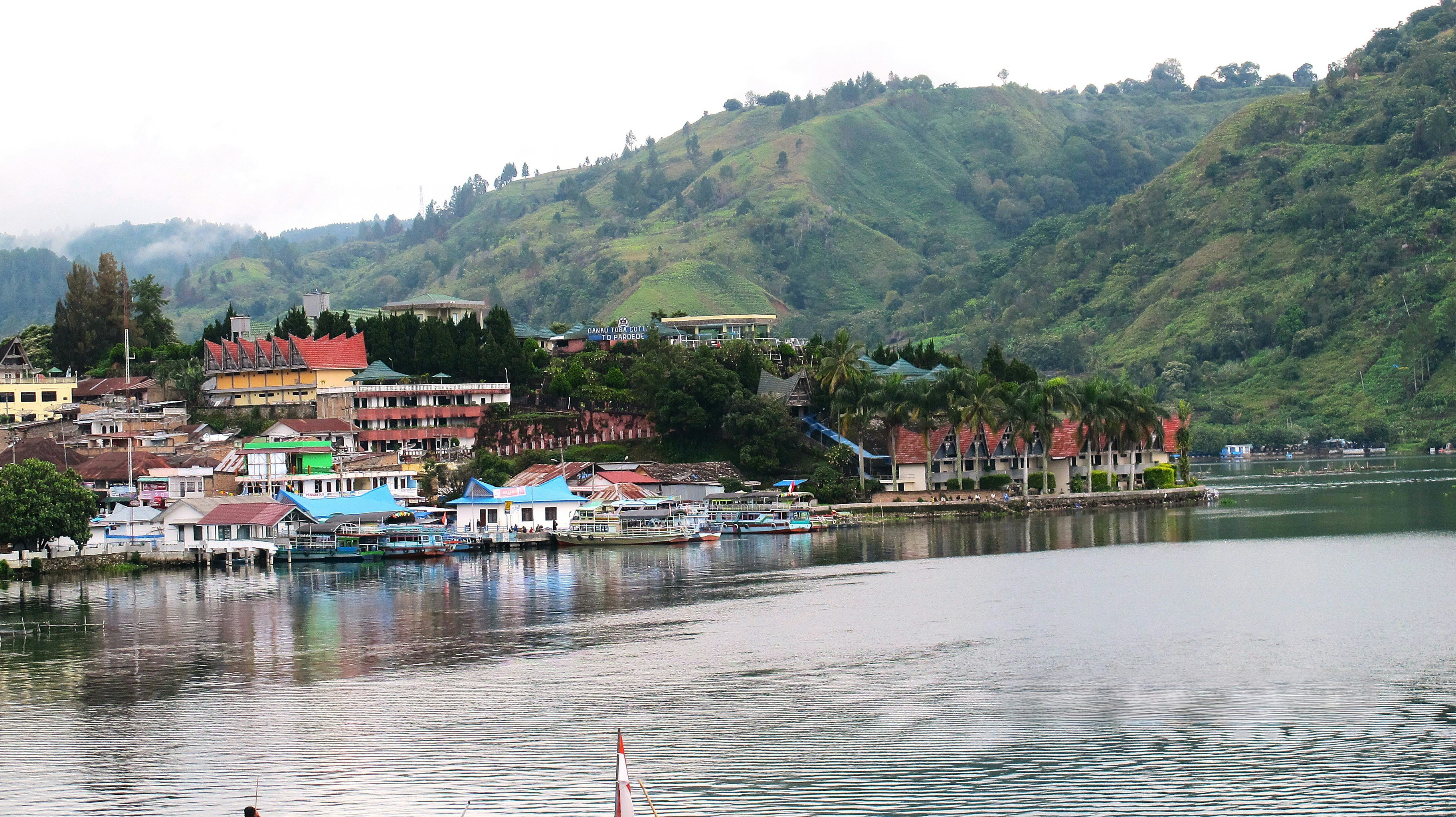 Bangunan dan perahu di sepanjang tepi Danau Toba di Sumatra Utara