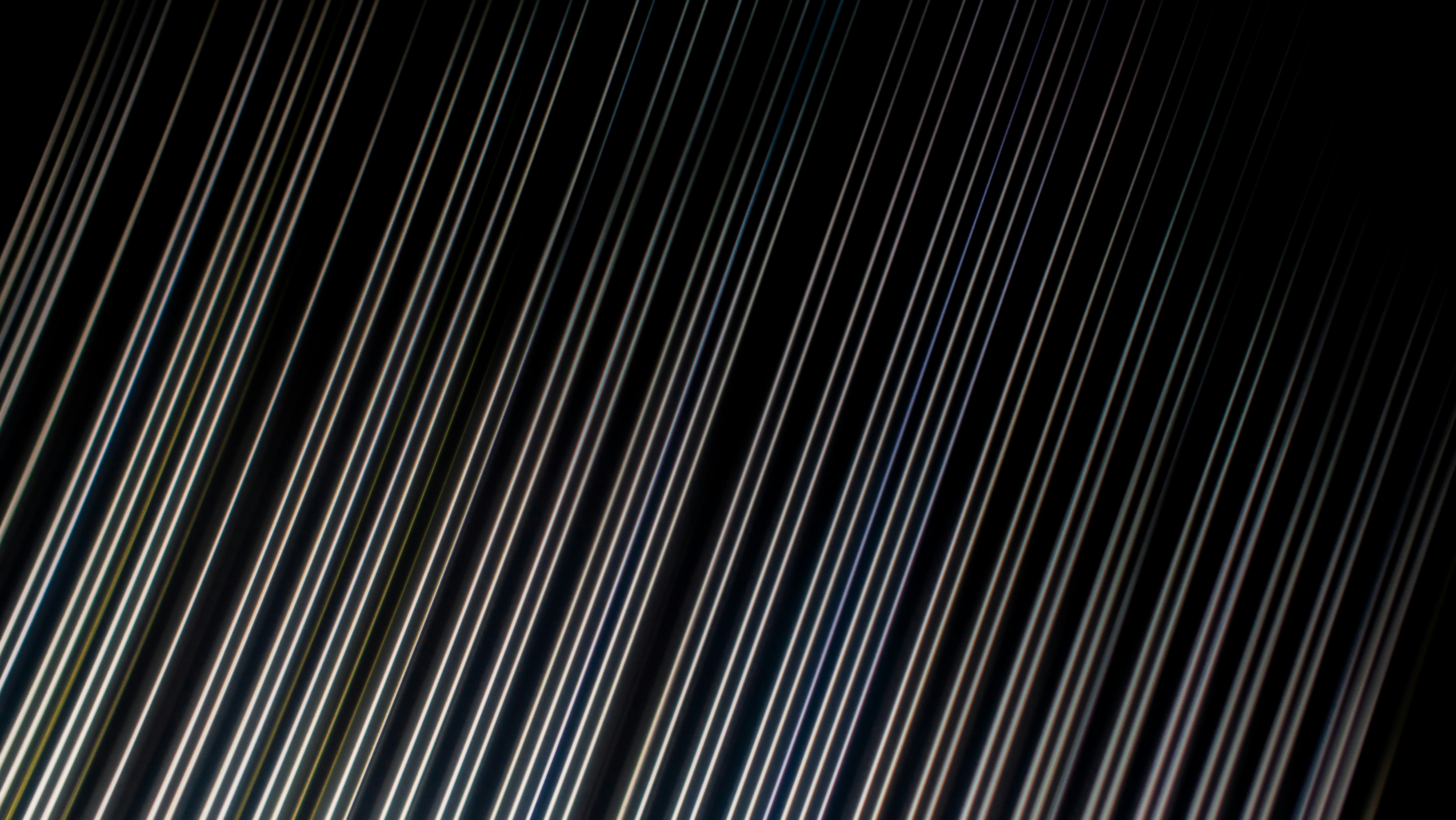 Diagonal white light streaks against a solid black background