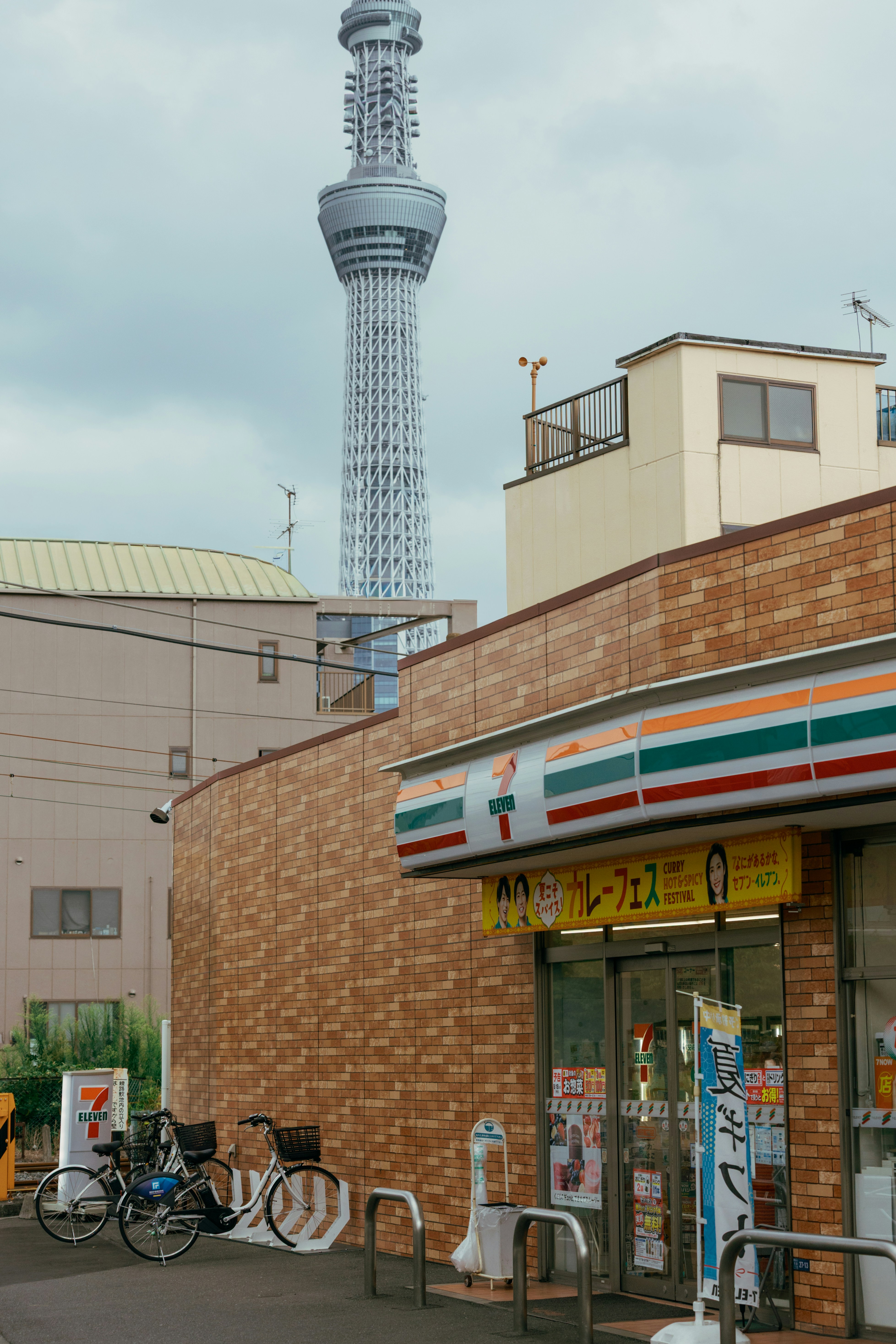 La tour Skytree de Tokyo s’élève au-dessus d’une supérette en brique 7-Eleven à Tokyo