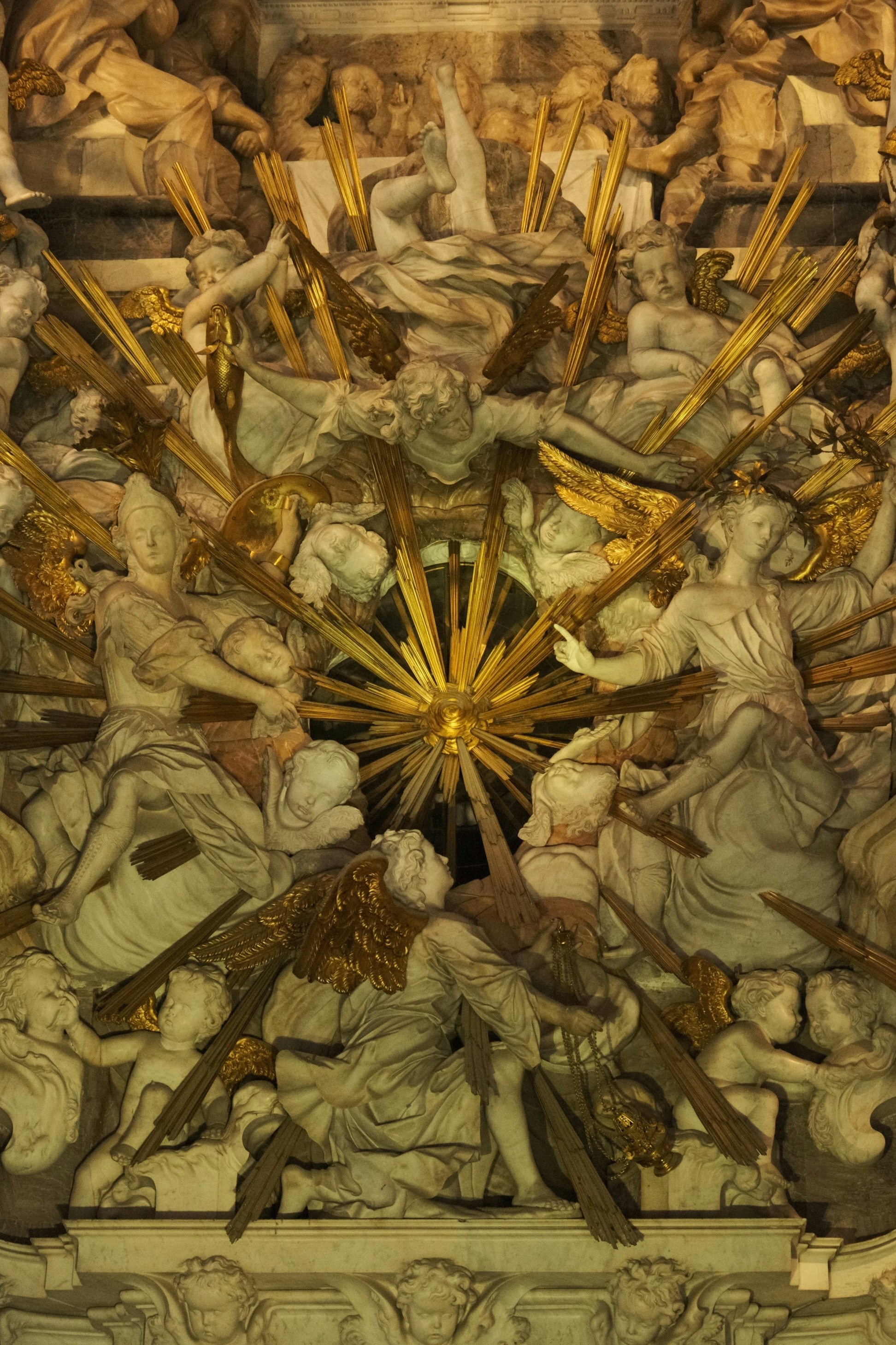 Ornate white marble sculptures of angels surrounding a central golden sunburst