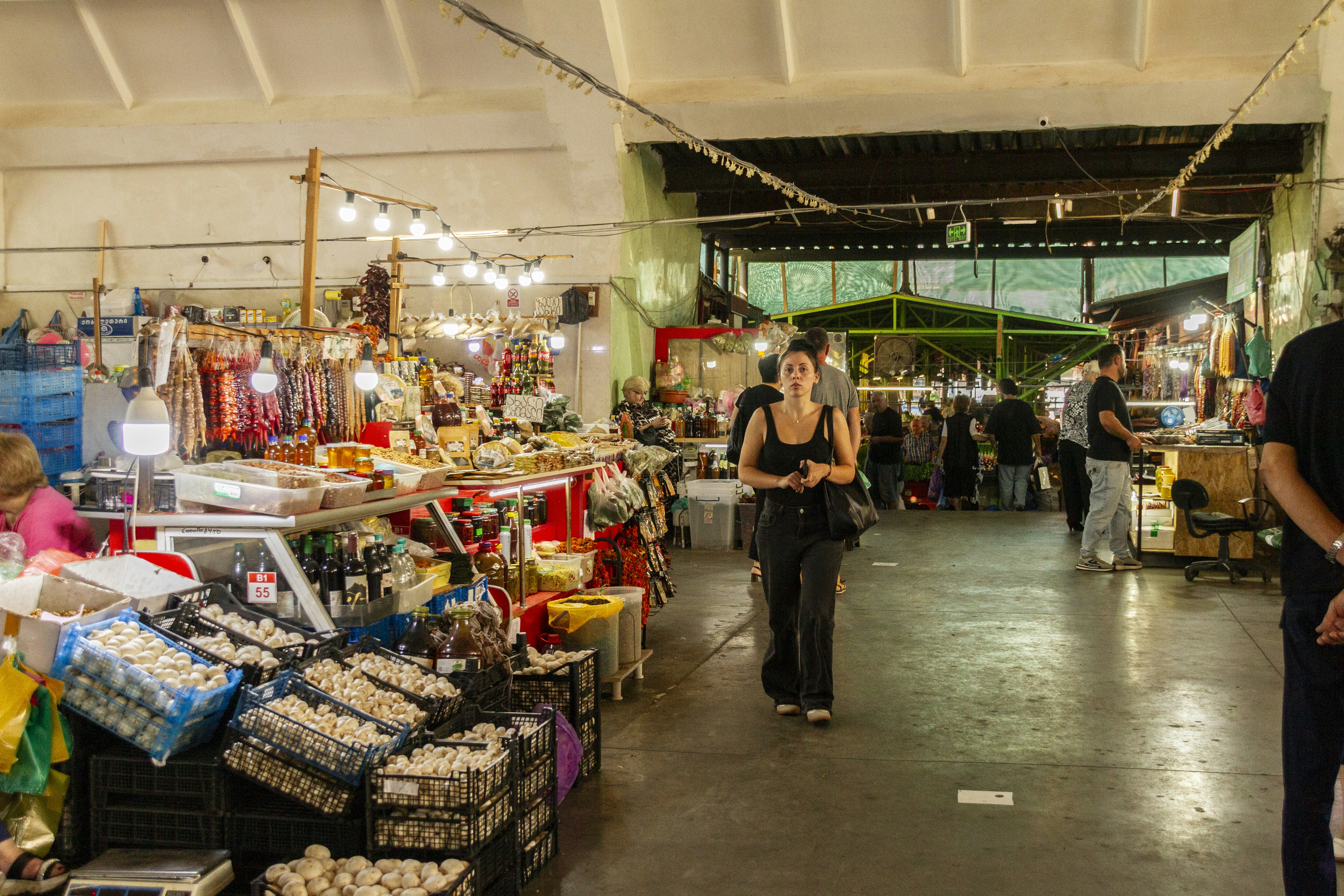 Shopper walking through a busy indoor produce market