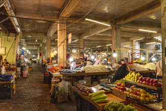 People shopping at stalls filled with fresh fruit and nuts in a market