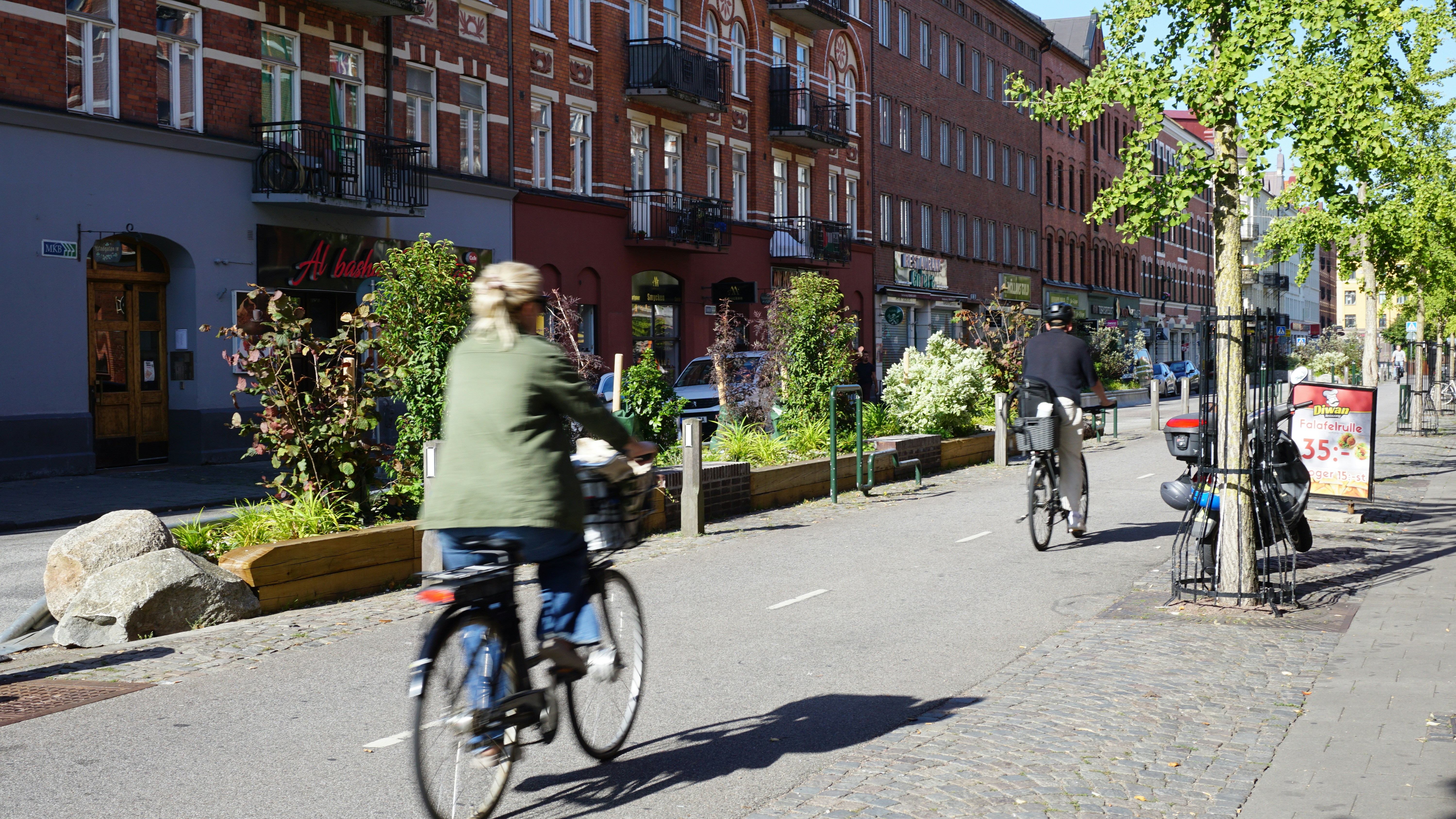 Two people cycling on a paved bike path