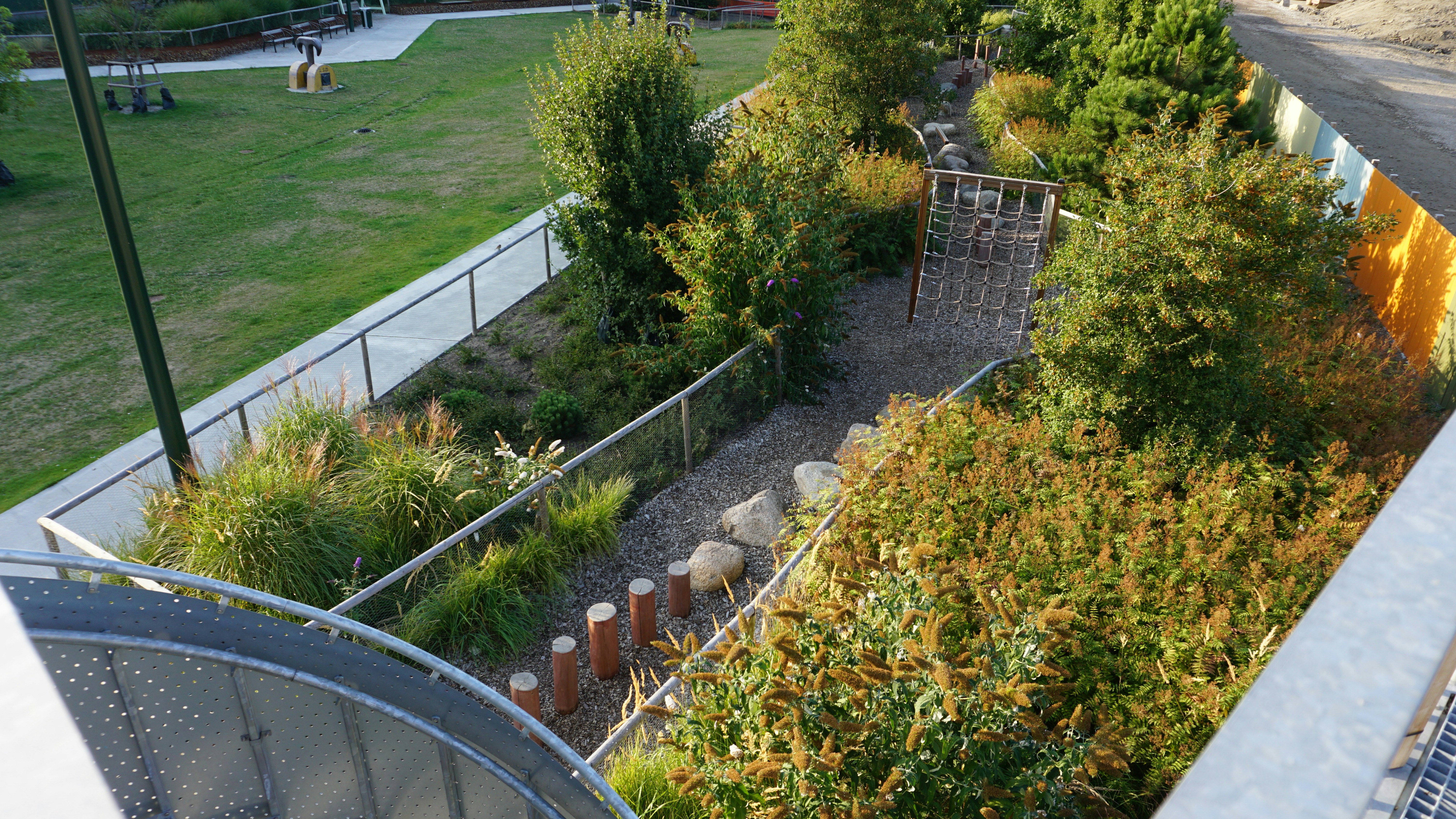 Playground with climbing net beside a garden