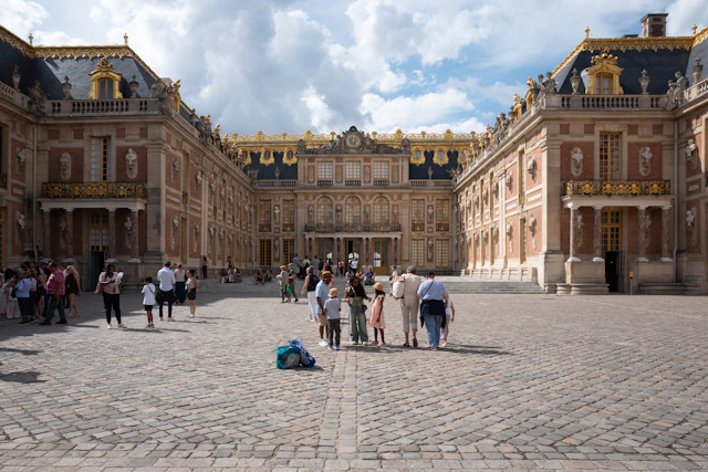 Visitors gathered in the marble courtyard in front of the Palace of Versailles