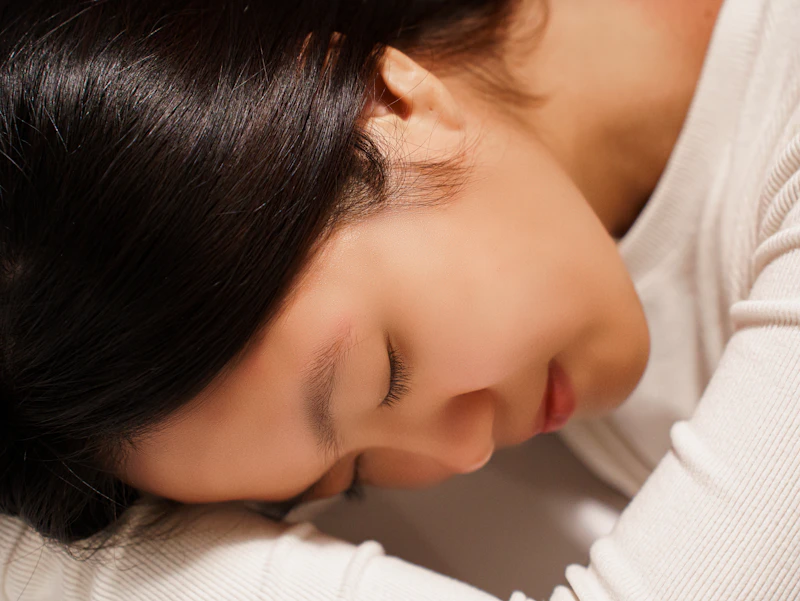 팔에 기대 곤히 잠든 여성