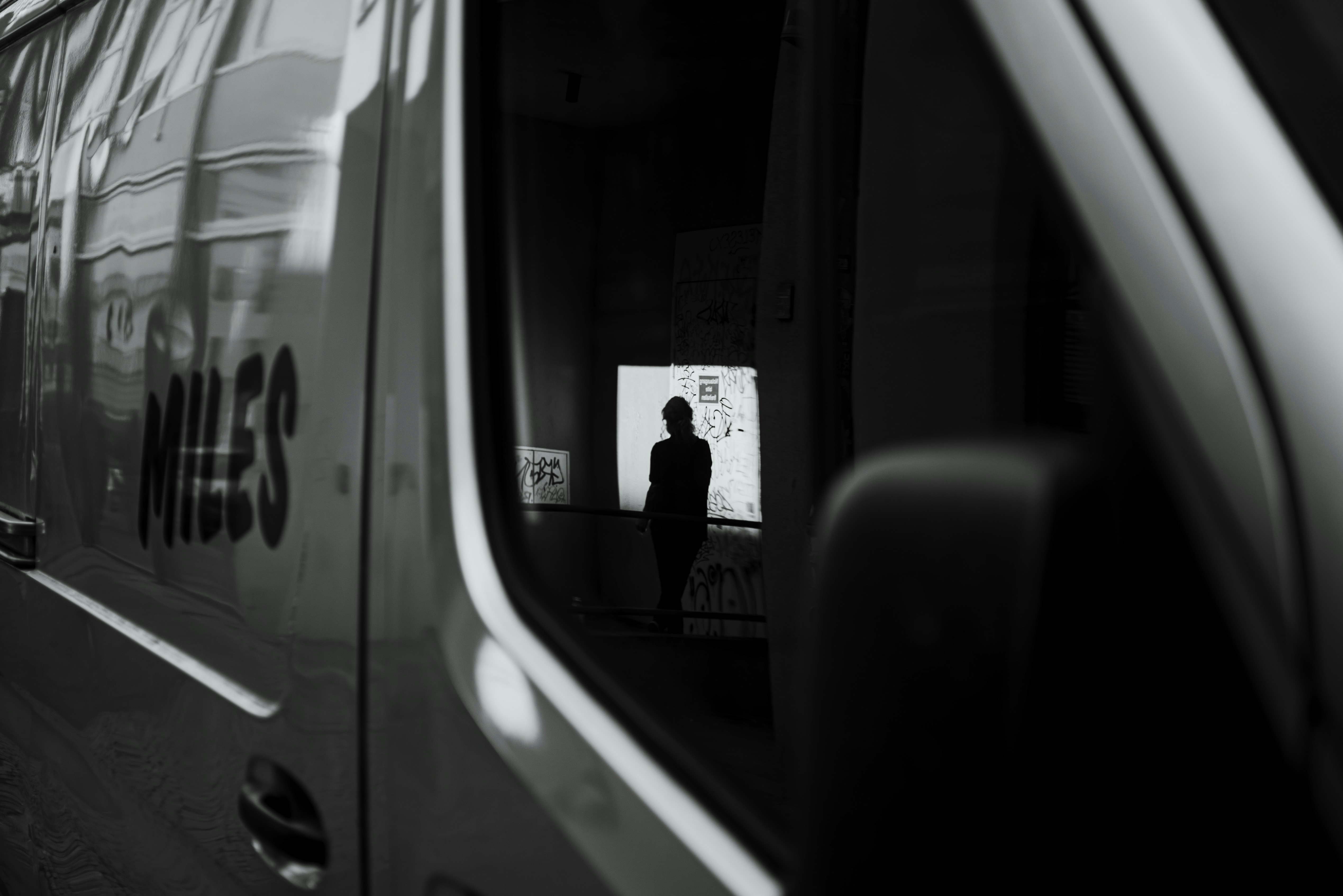 A silhouette of a person reflected in the side of a van in Berlin