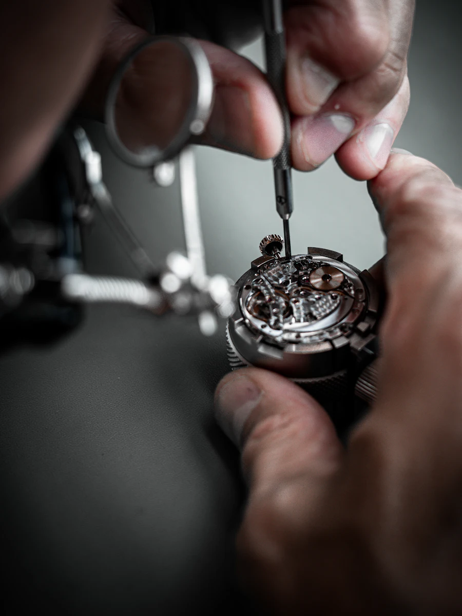 A watchmaker working on a movement with a loupe