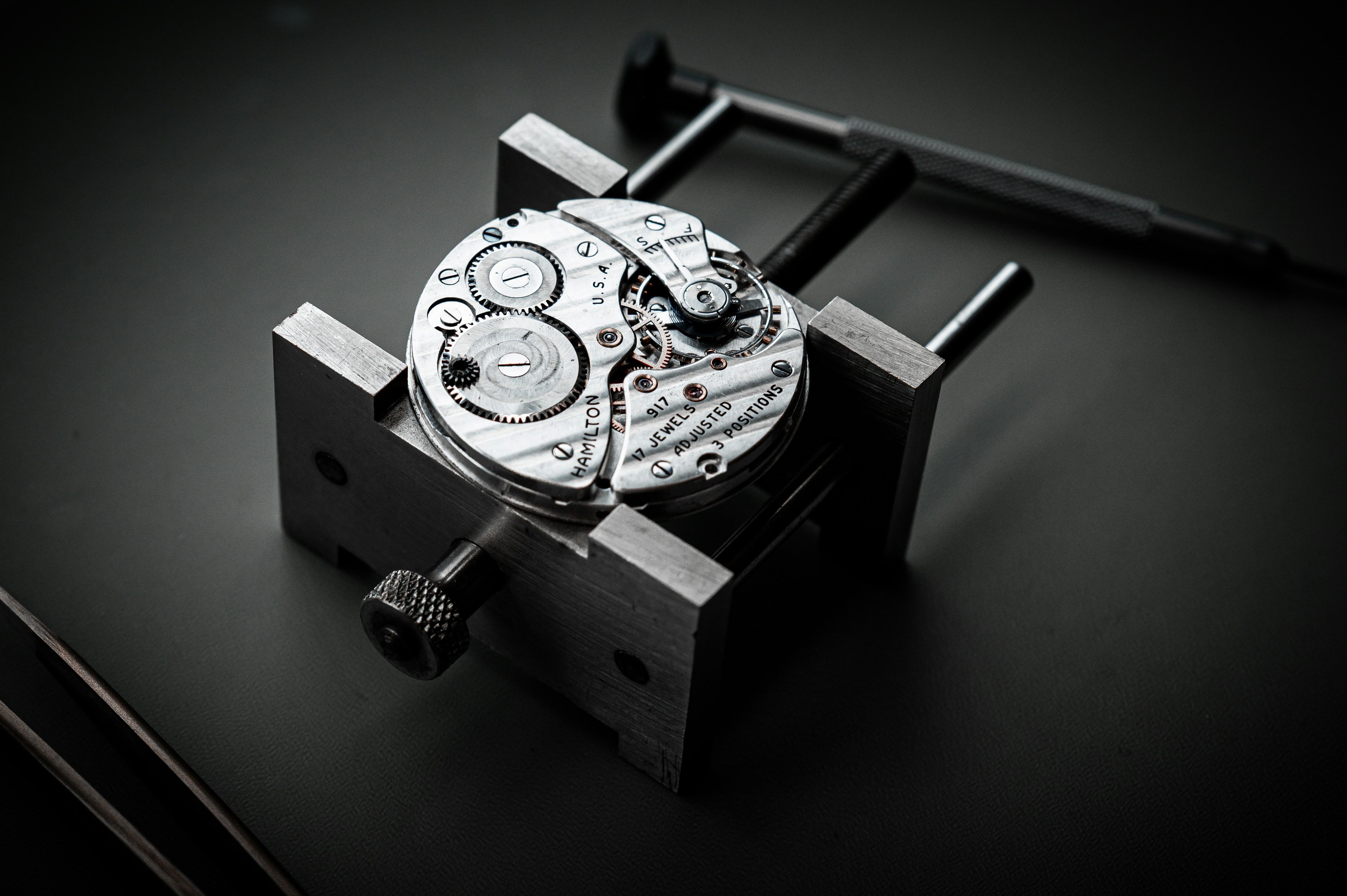A vintage Hamilton 917 movement in a holder beside a screwdriver