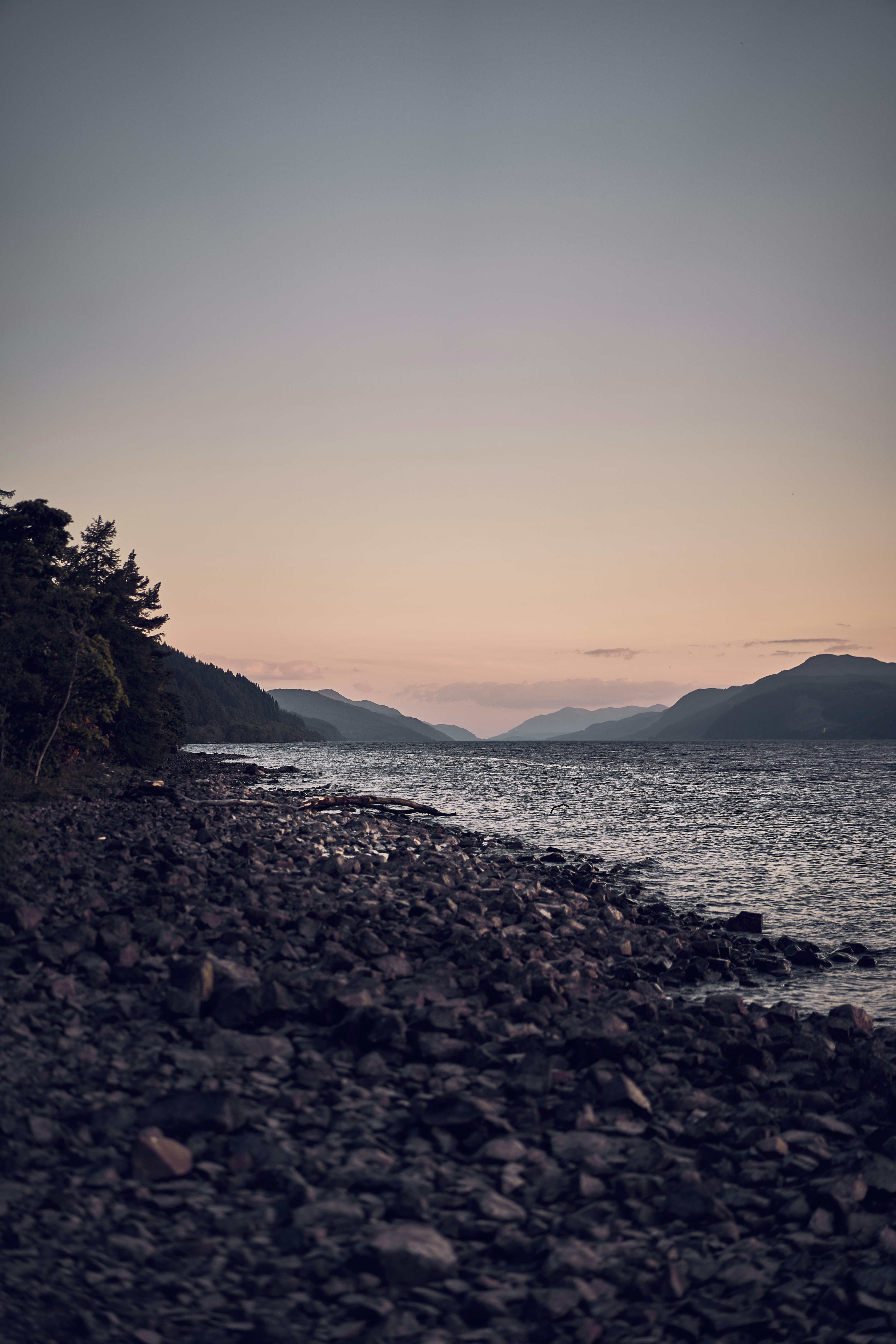 The rocky shore and mountain scenery of Loch Lomond in Scotland.
