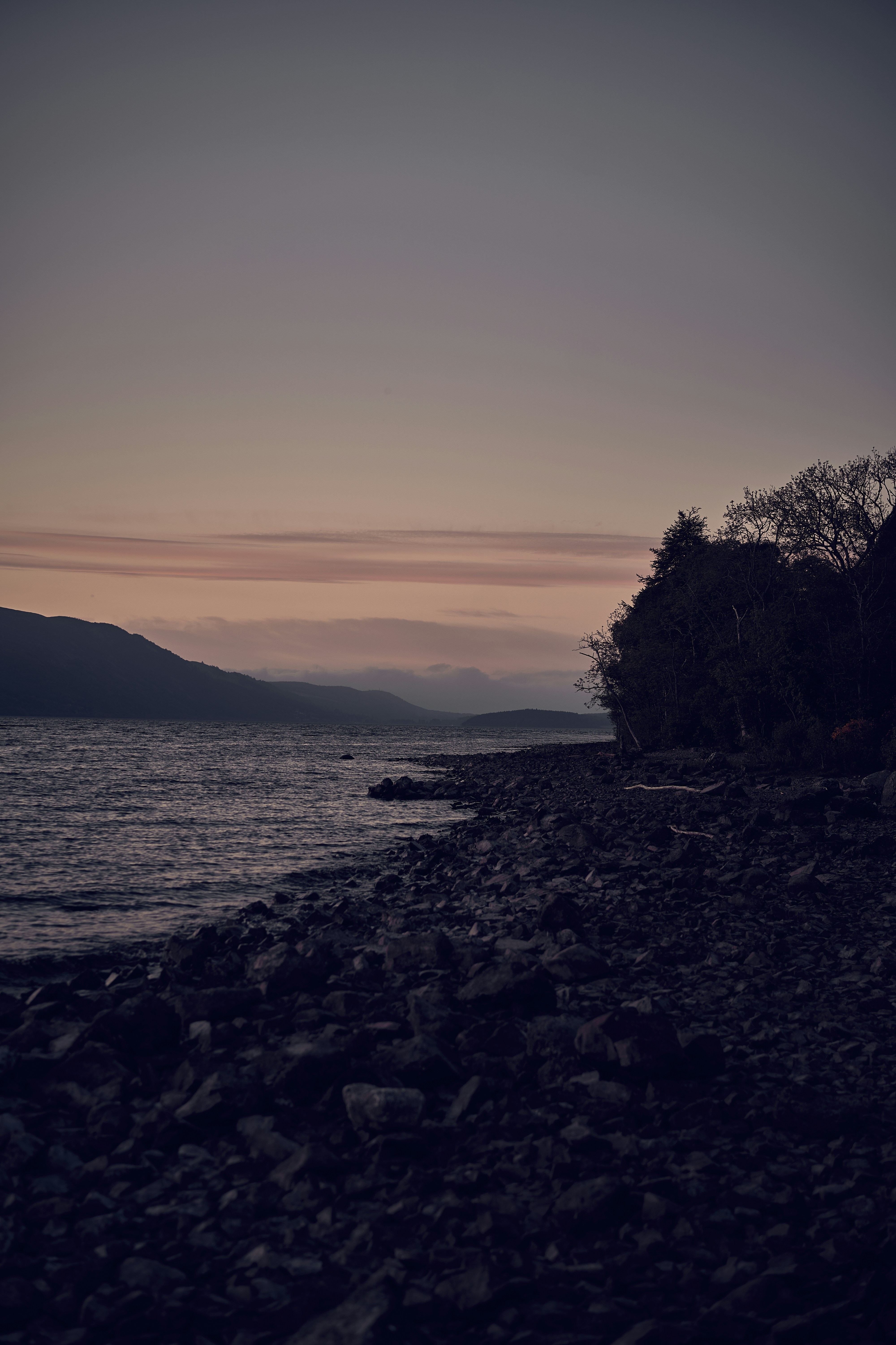 The rocky shore and mountain scenery of Loch Lomond in Scotland.