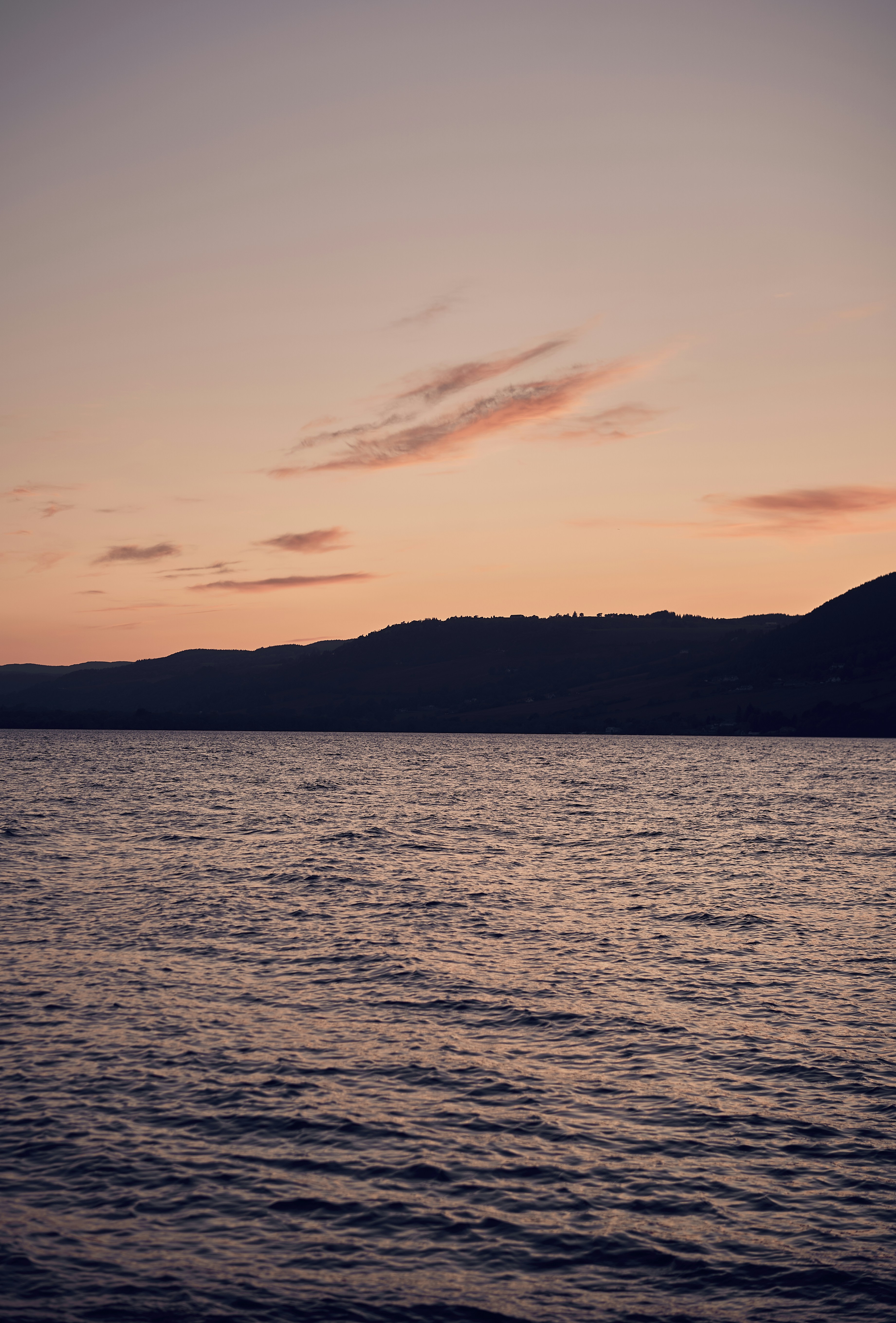 The rocky shore and mountain scenery of Loch Lomond in Scotland.