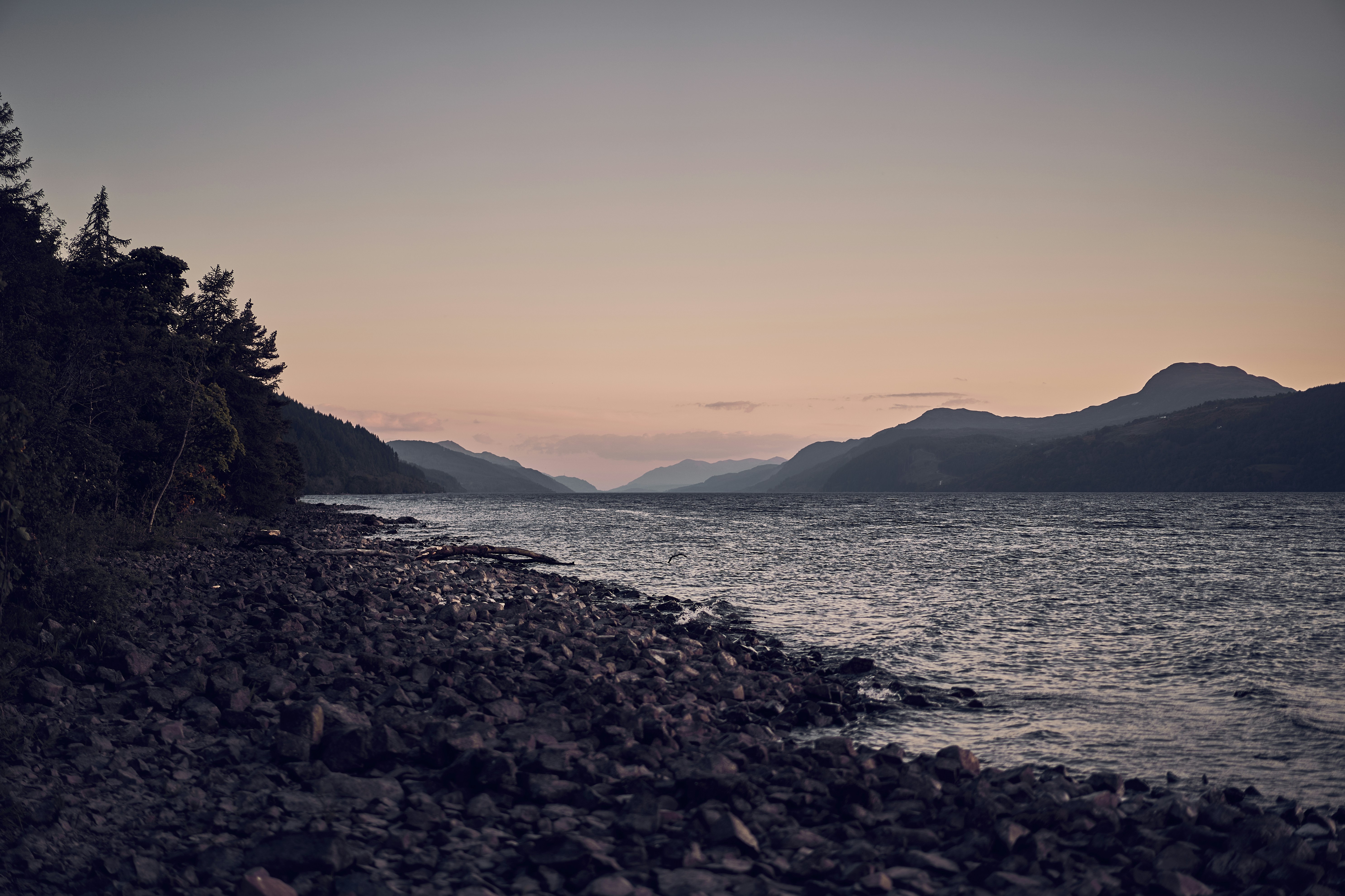 The rocky shore and mountain scenery of Loch Lomond in Scotland.