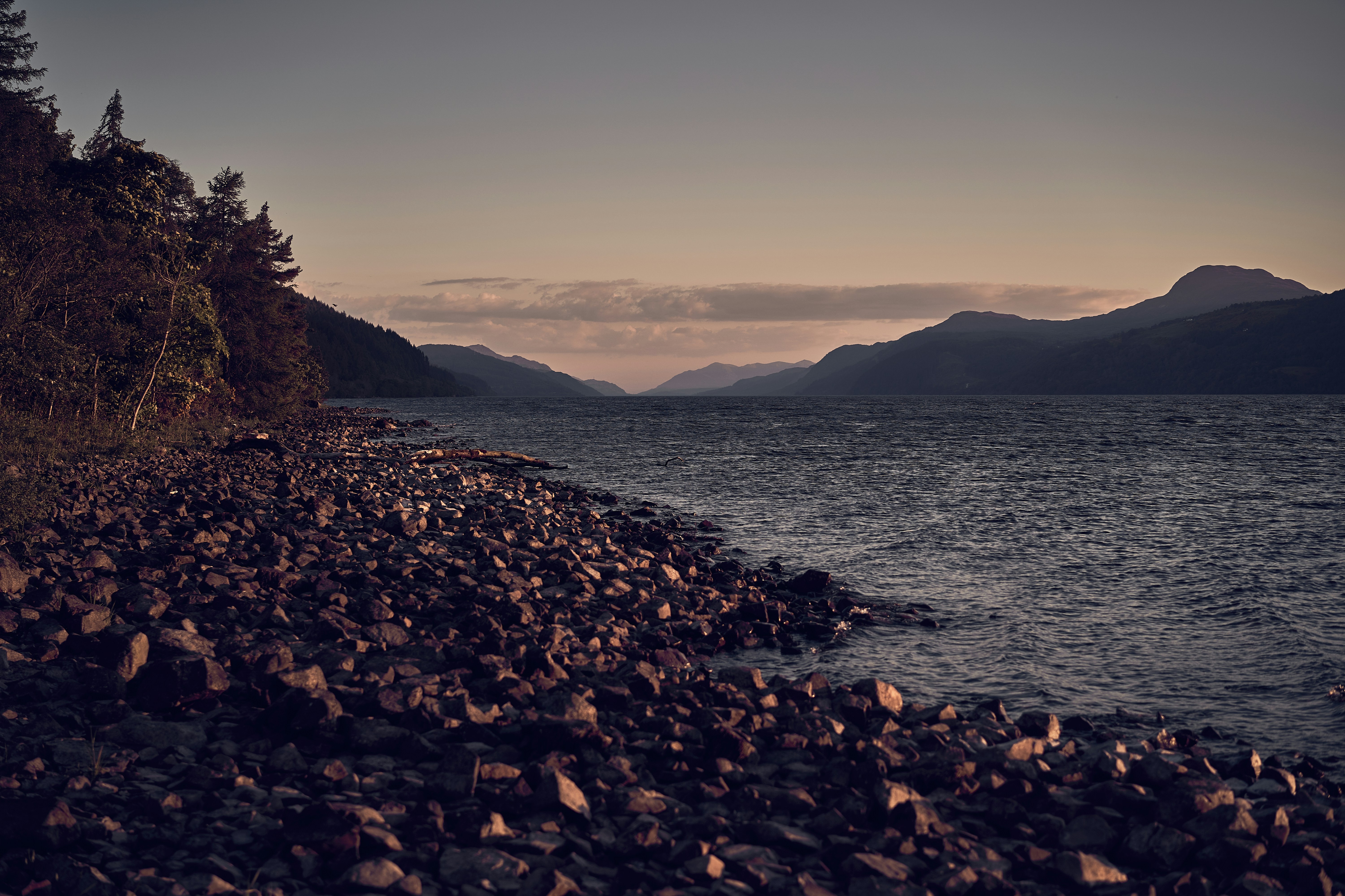 The rocky shore and mountain scenery of Loch Lomond in Scotland.