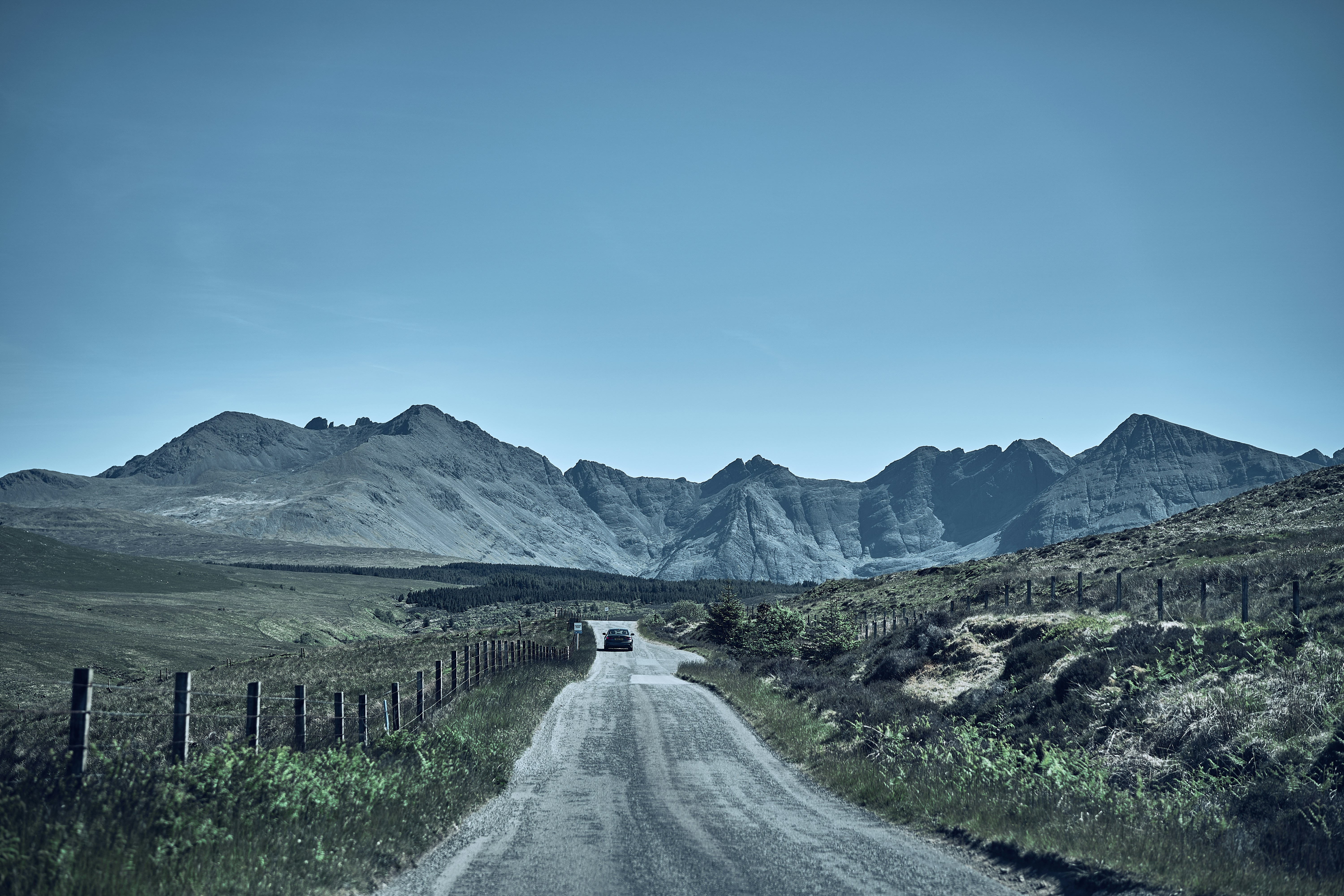 A single-track road leading toward the Cuillin mountains on the Isle of Skye.