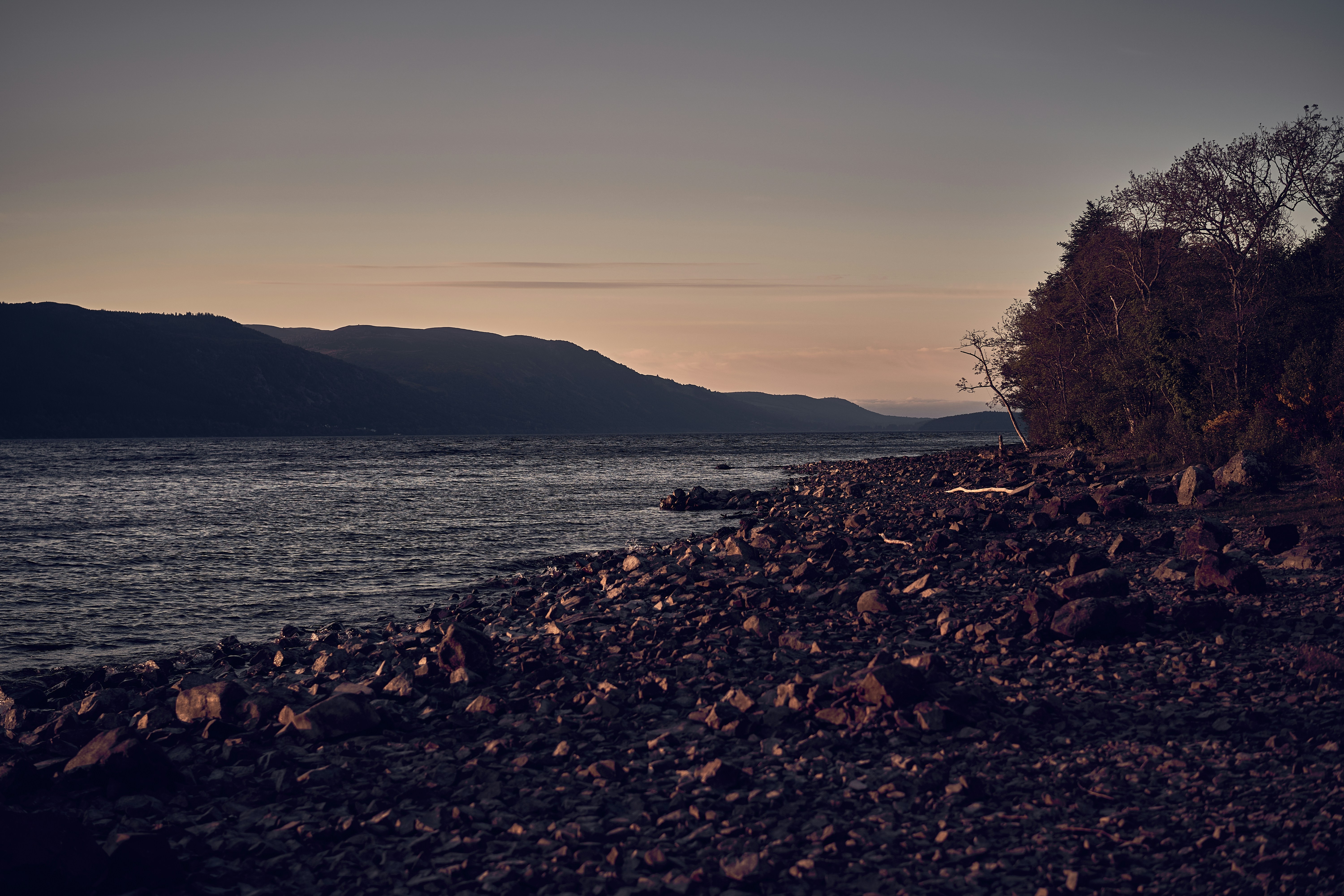 The rocky shore and mountain scenery of Loch Lomond in Scotland.