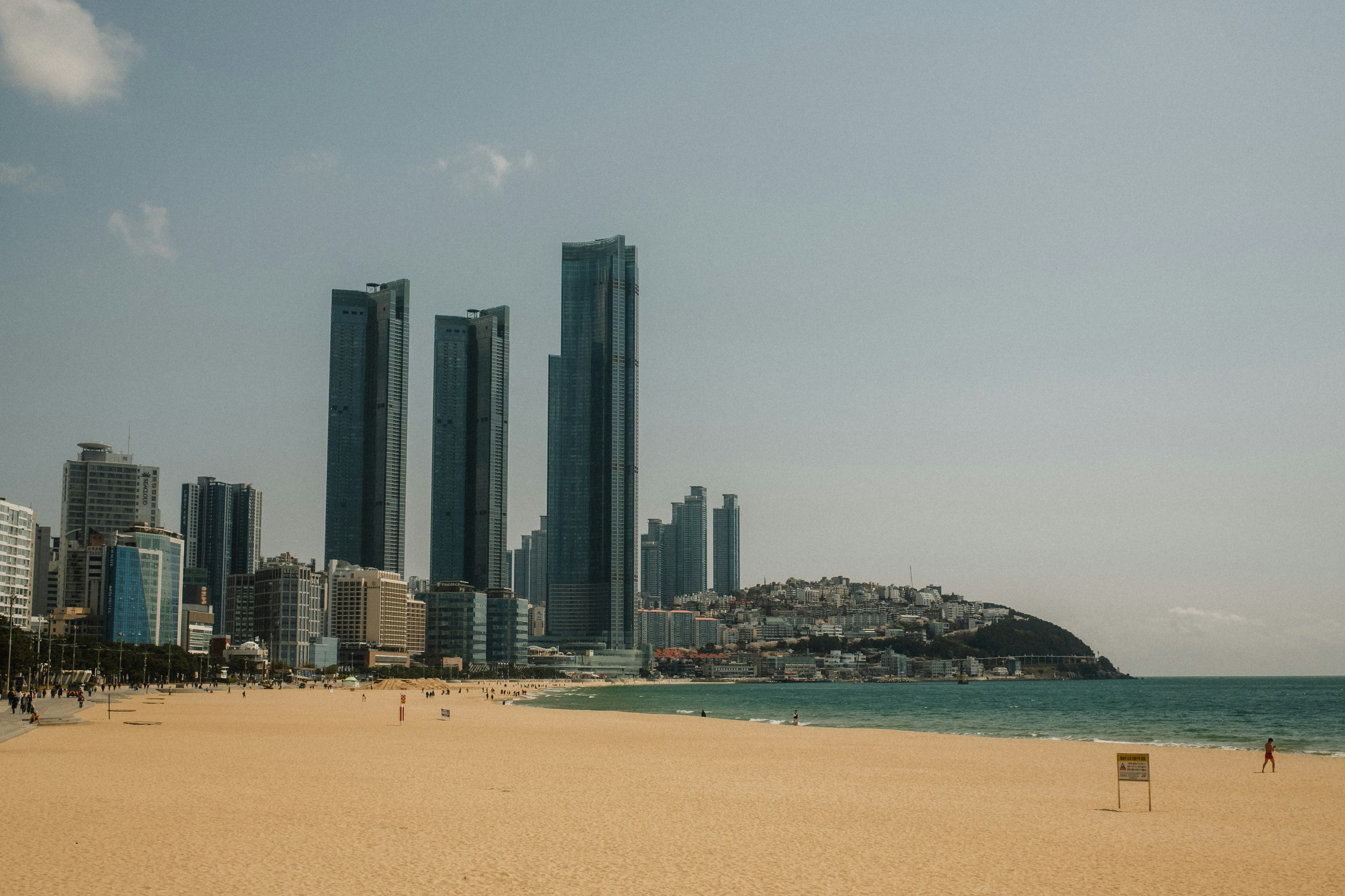 Skyscrapers rising above a sandy beach and the ocean in Busan, South Korea