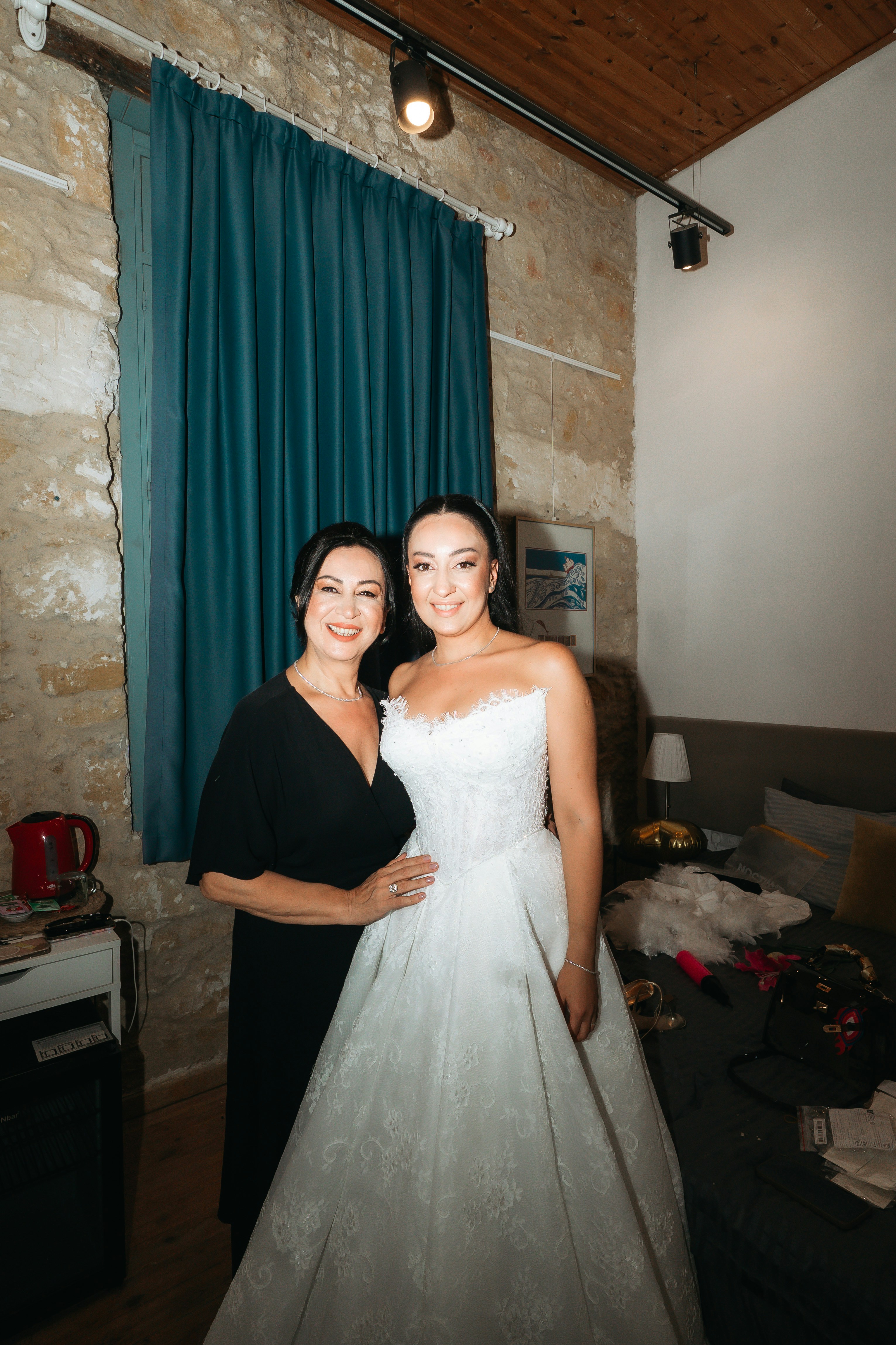 Uma mulher de vestido preto ao lado de uma mulher de vestido de noiva branco