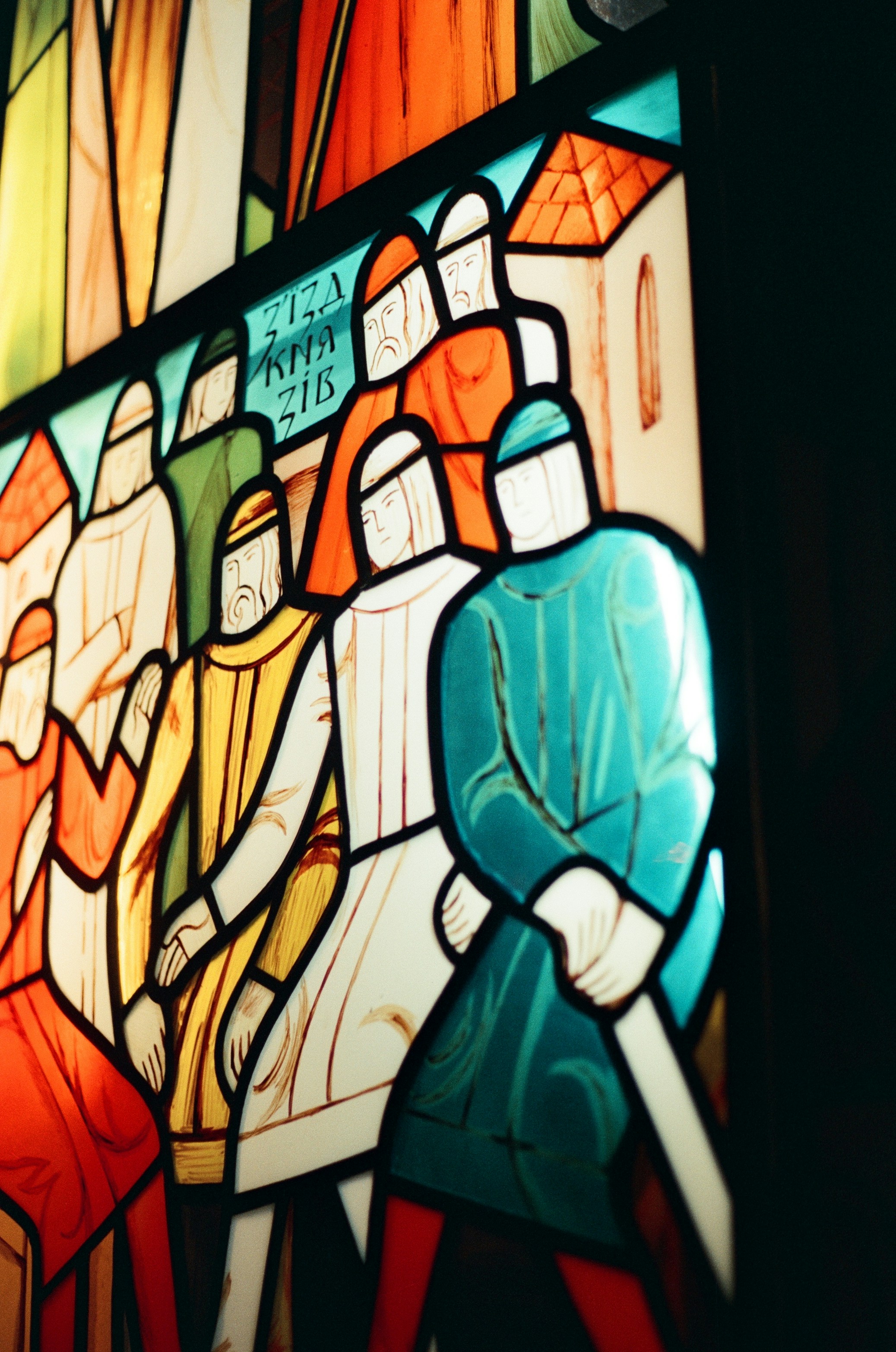 Stained glass window depicting a group of people in medieval clothing