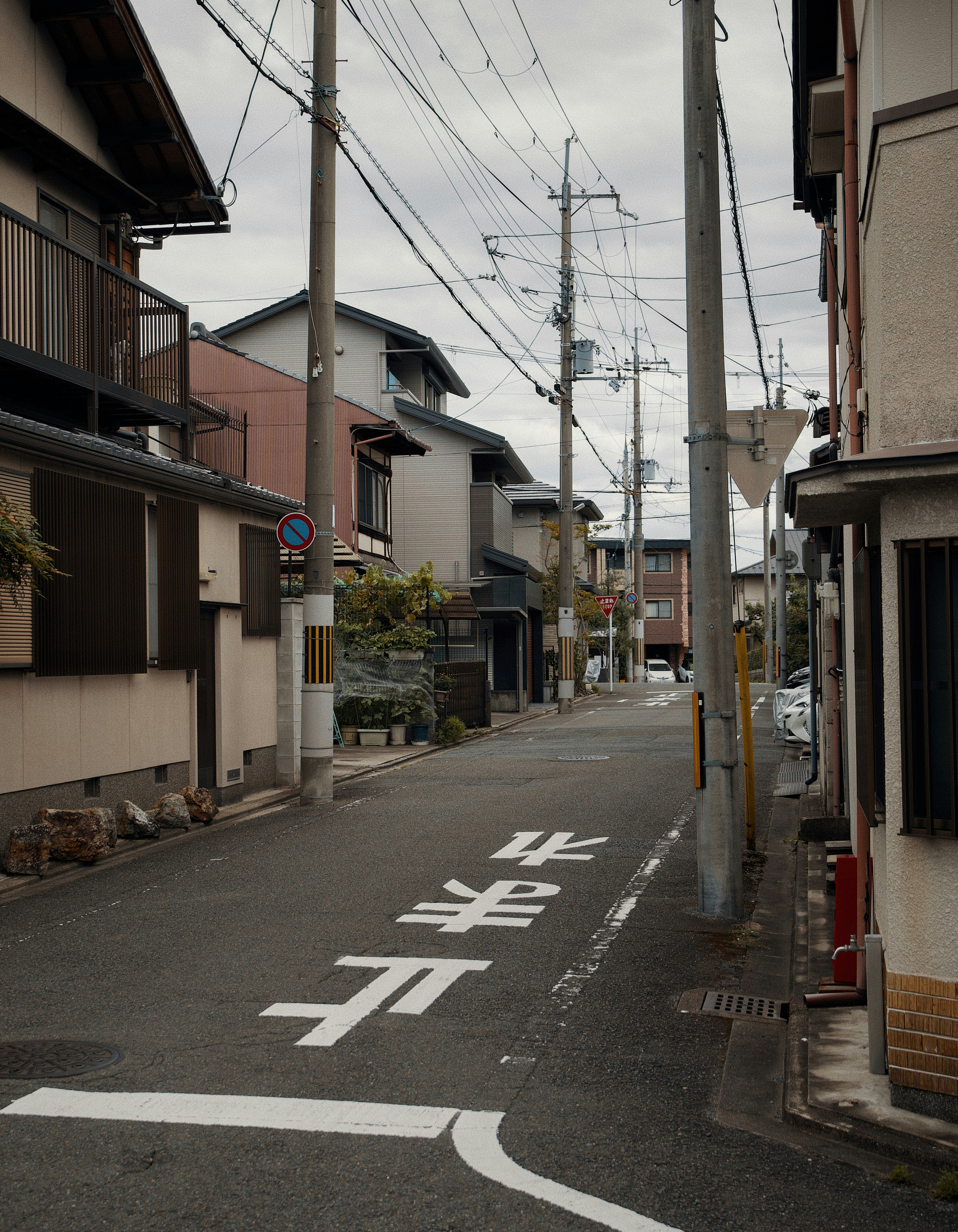 Eine schmale Wohnstraße in Japan mit Strommasten und Freileitungen