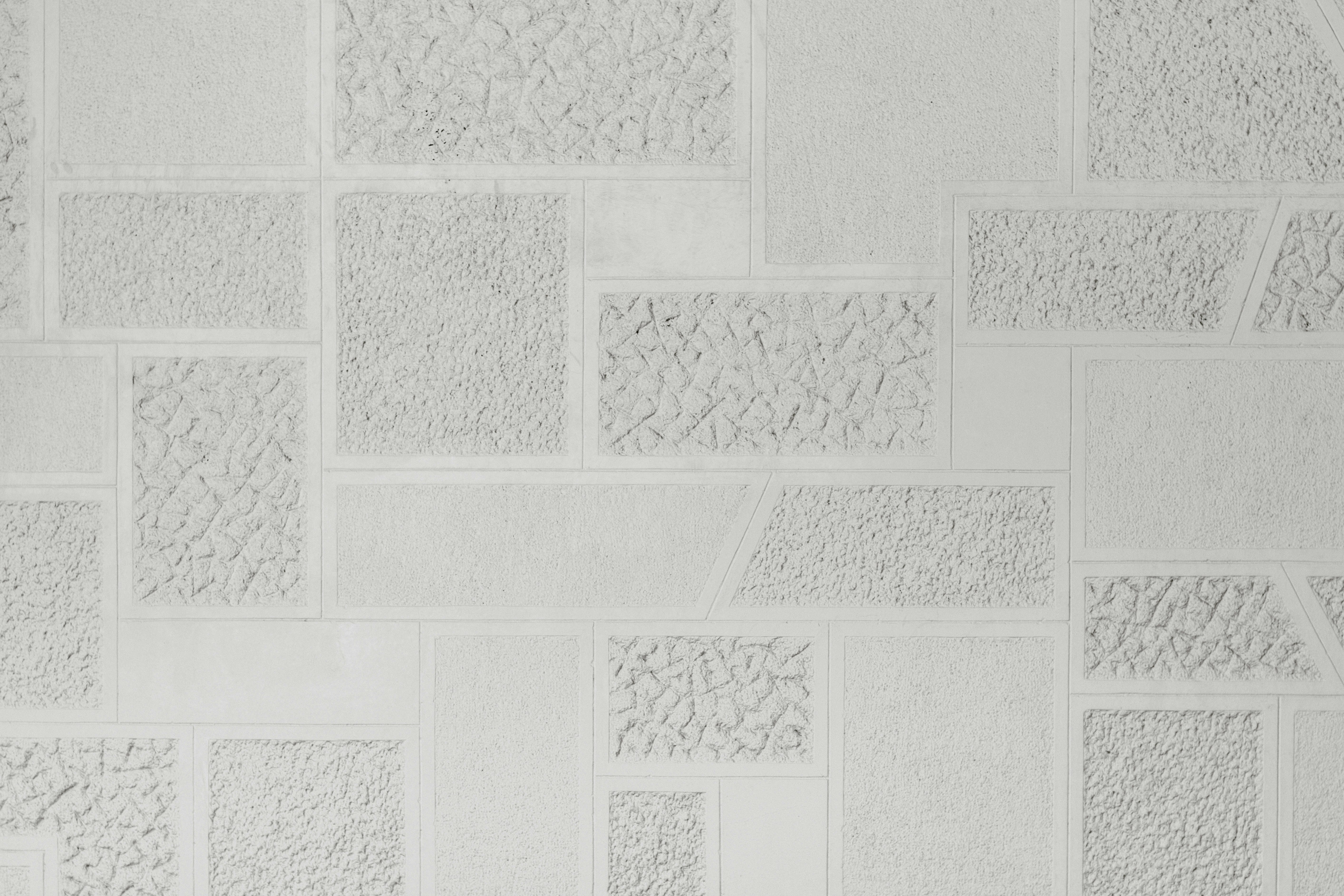 A white wall with a geometric pattern of smooth and textured rectangular panels