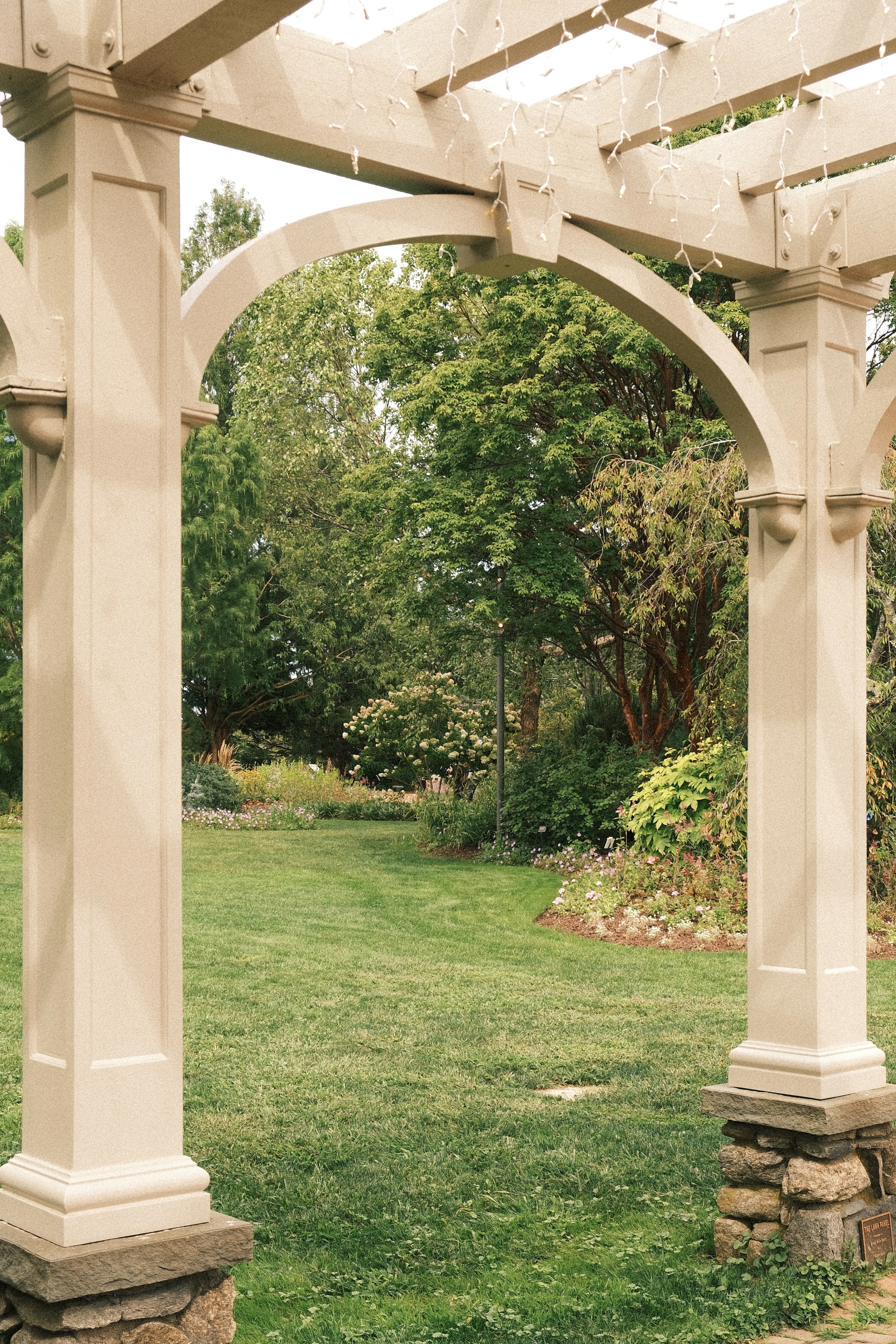 Beige wooden pergola framing a green garden