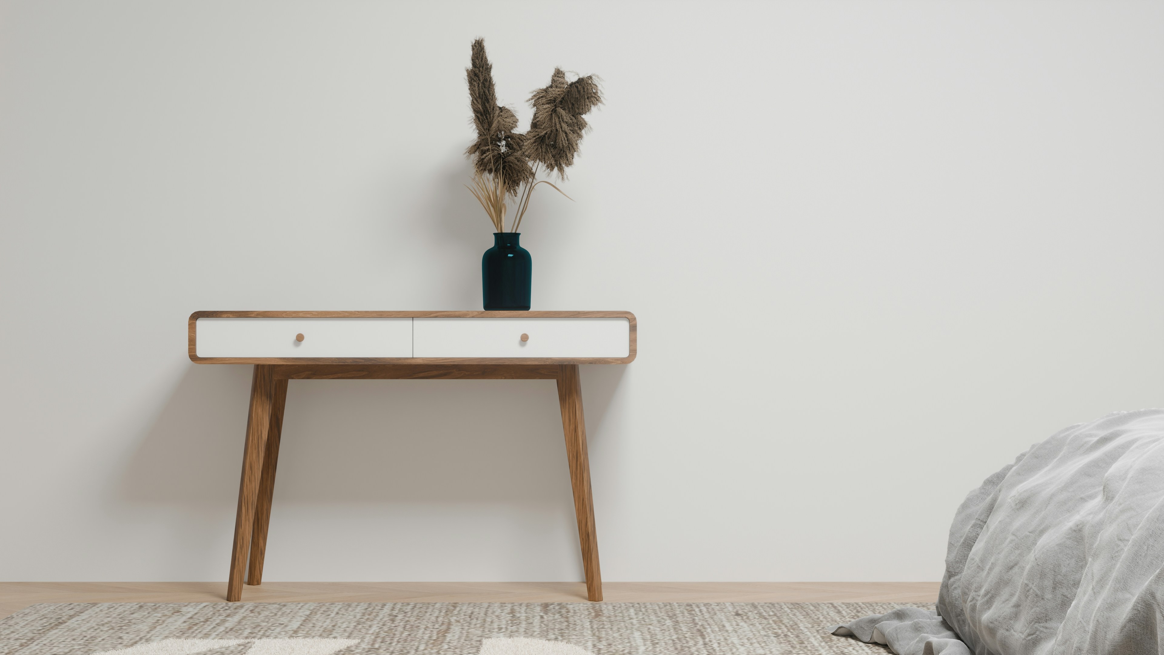 Una consola de madera con cajones blancos y un jarrón oscuro de hierba seca
