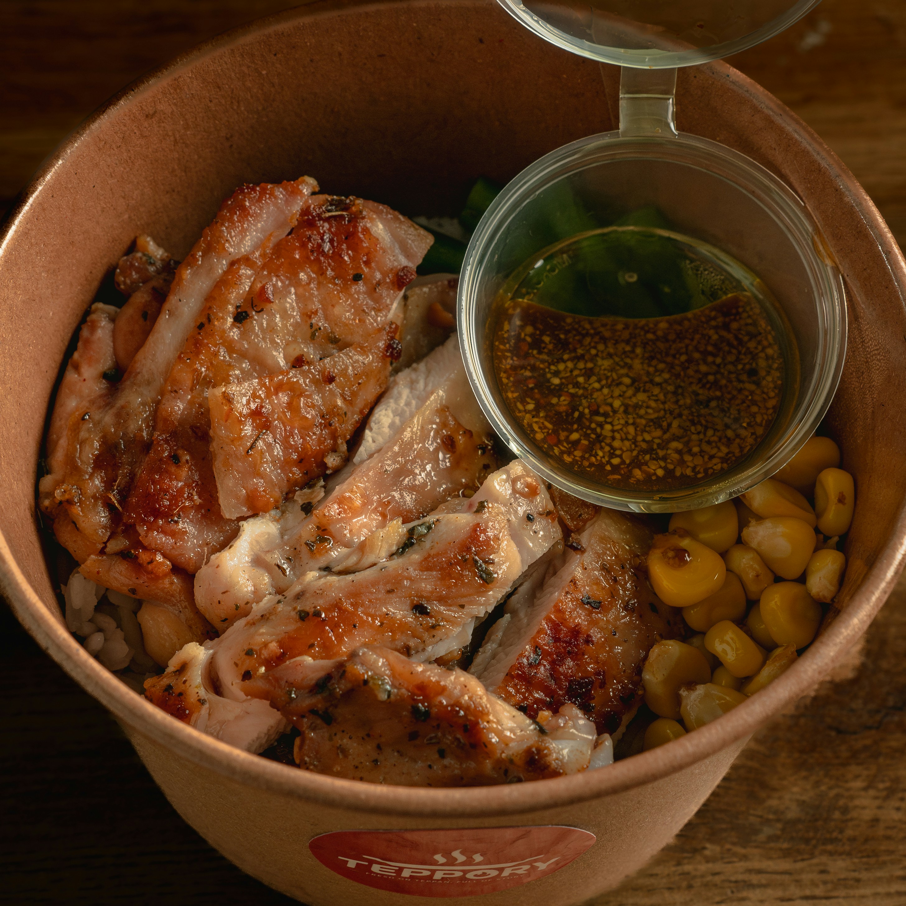 Gegrilltes Hähnchen mit Mais und Soße in einer Papierschüssel zum Mittagessen