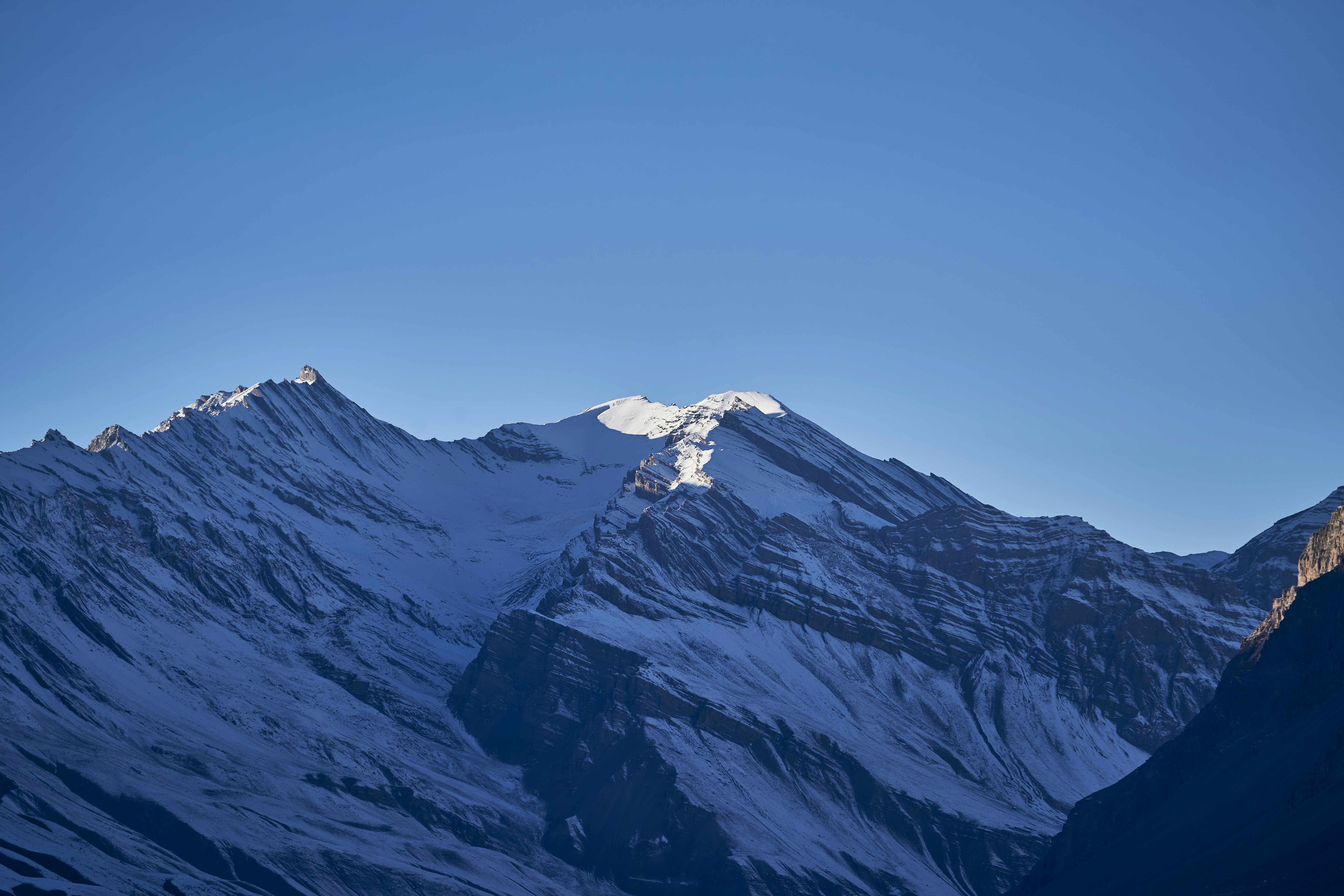Snow-covered mountain peaks under a clear blue sky