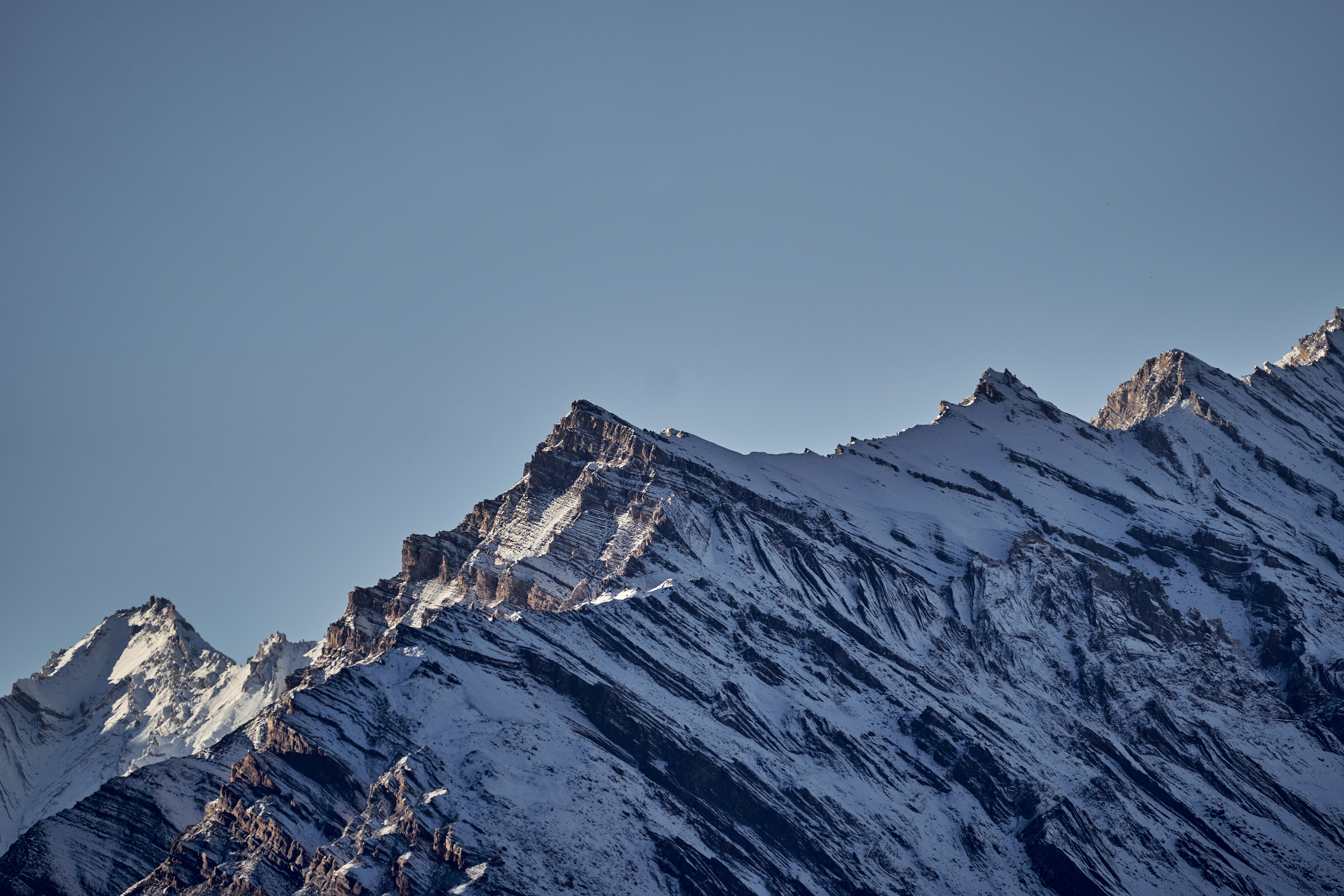 Snow-covered mountain peaks against a clear blue sky