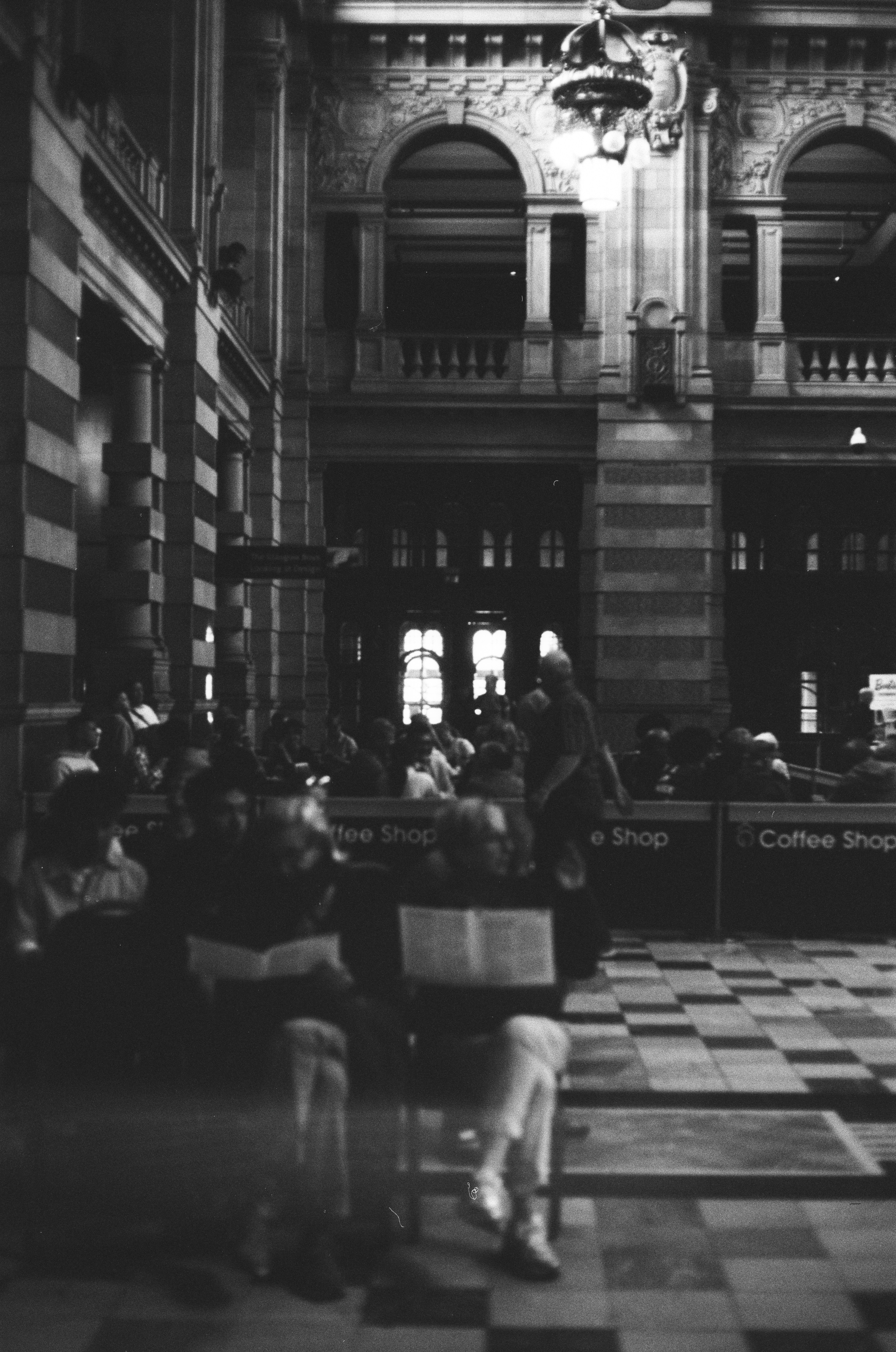 People sitting at tables in a coffee shop inside a grand historic building