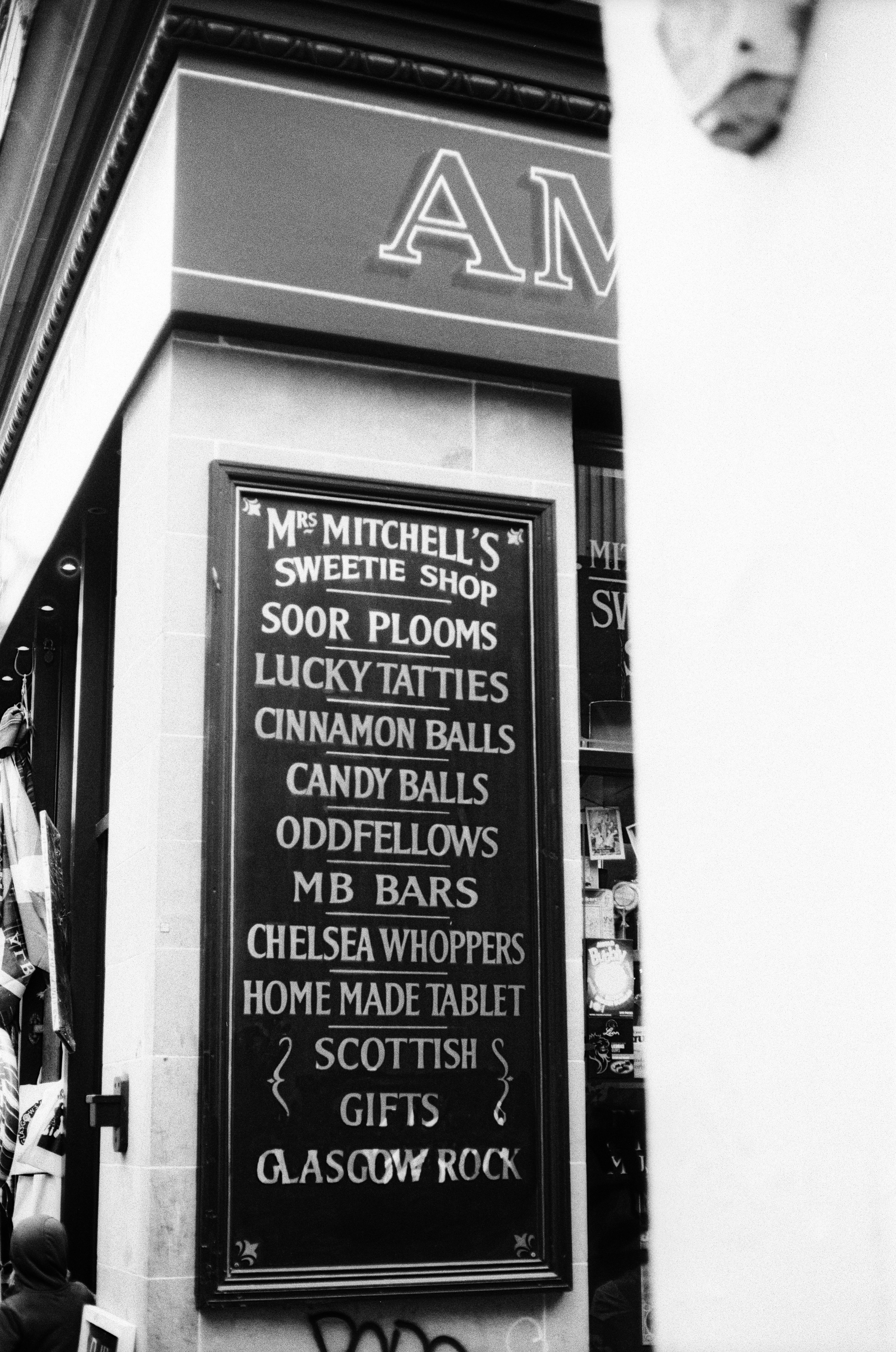 A black and white sign listing sweets outside Mrs Mitchell's Sweetie Shop