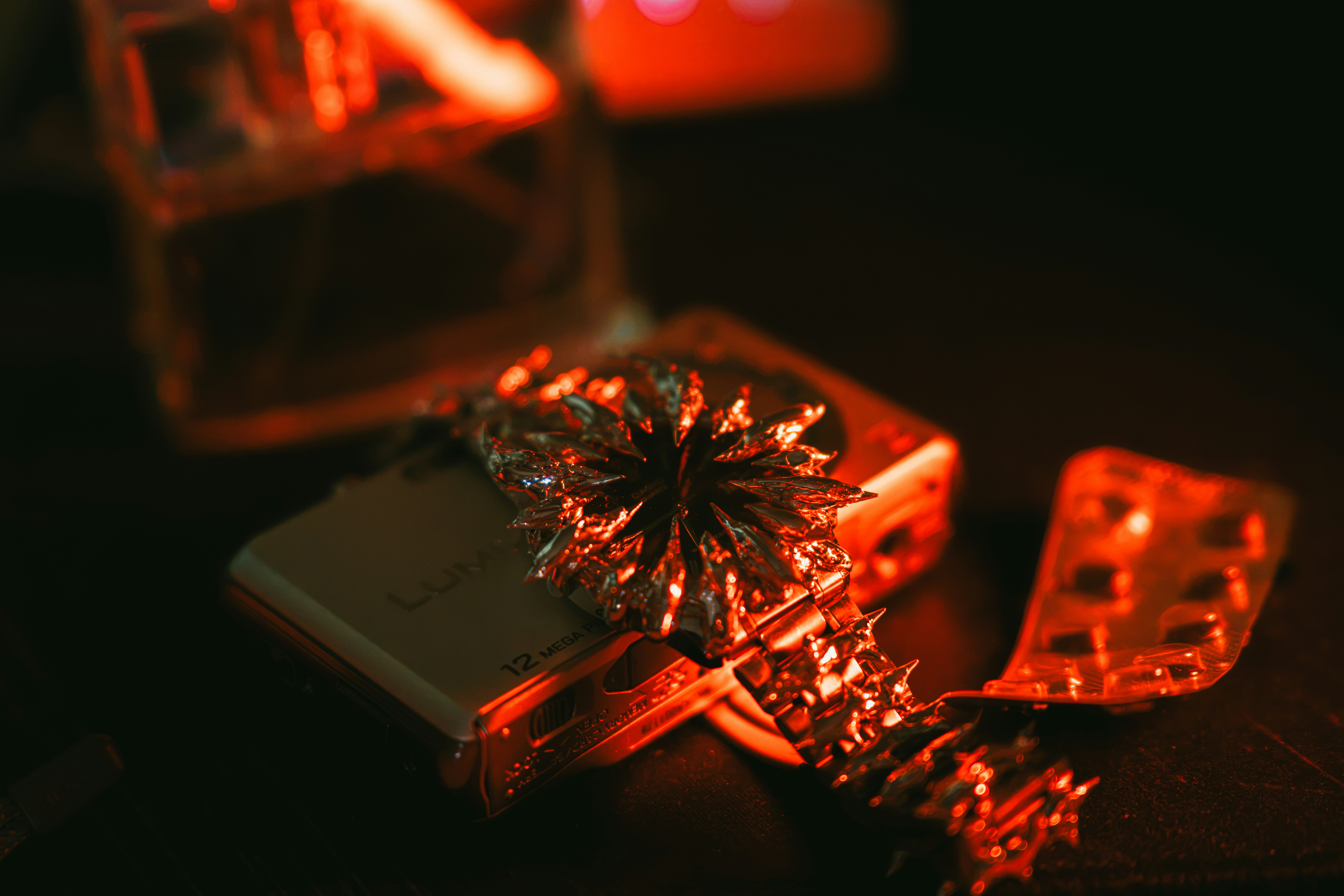 A metallic watch with a spiky face resting on a digital camera