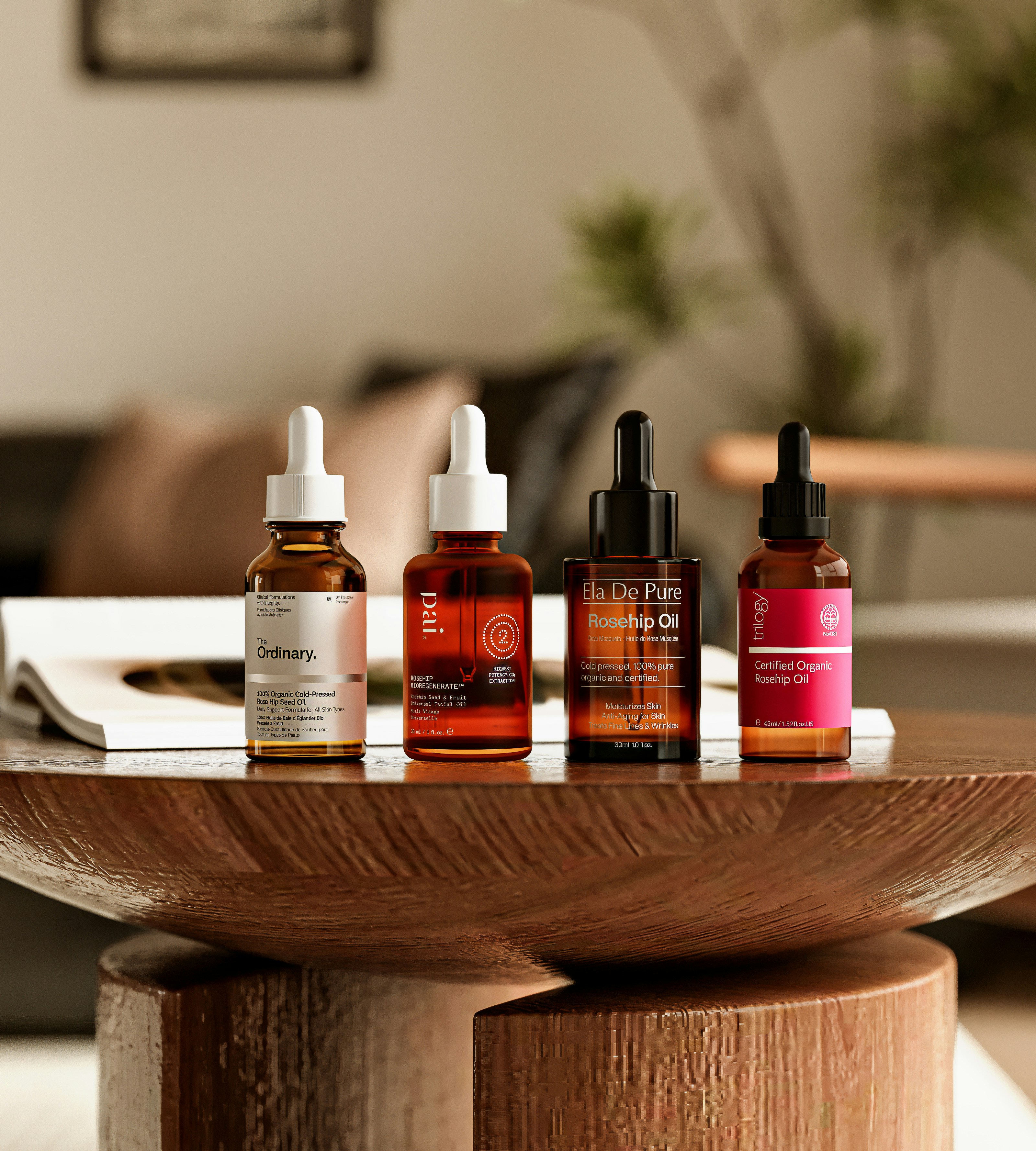 Four amber glass dropper bottles of facial oil on a carved wooden pedestal