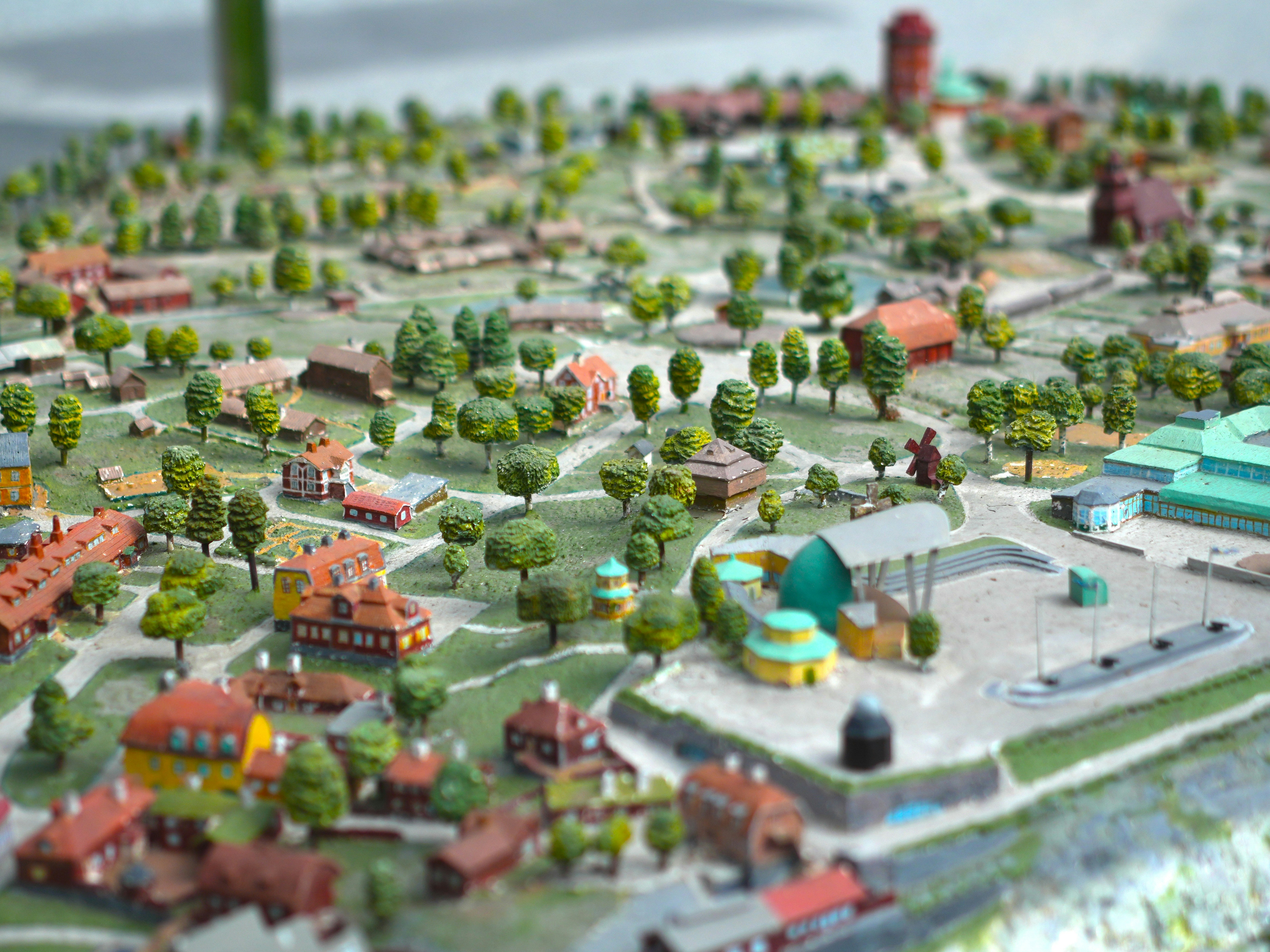 A miniature scale model of a town with small houses and green trees