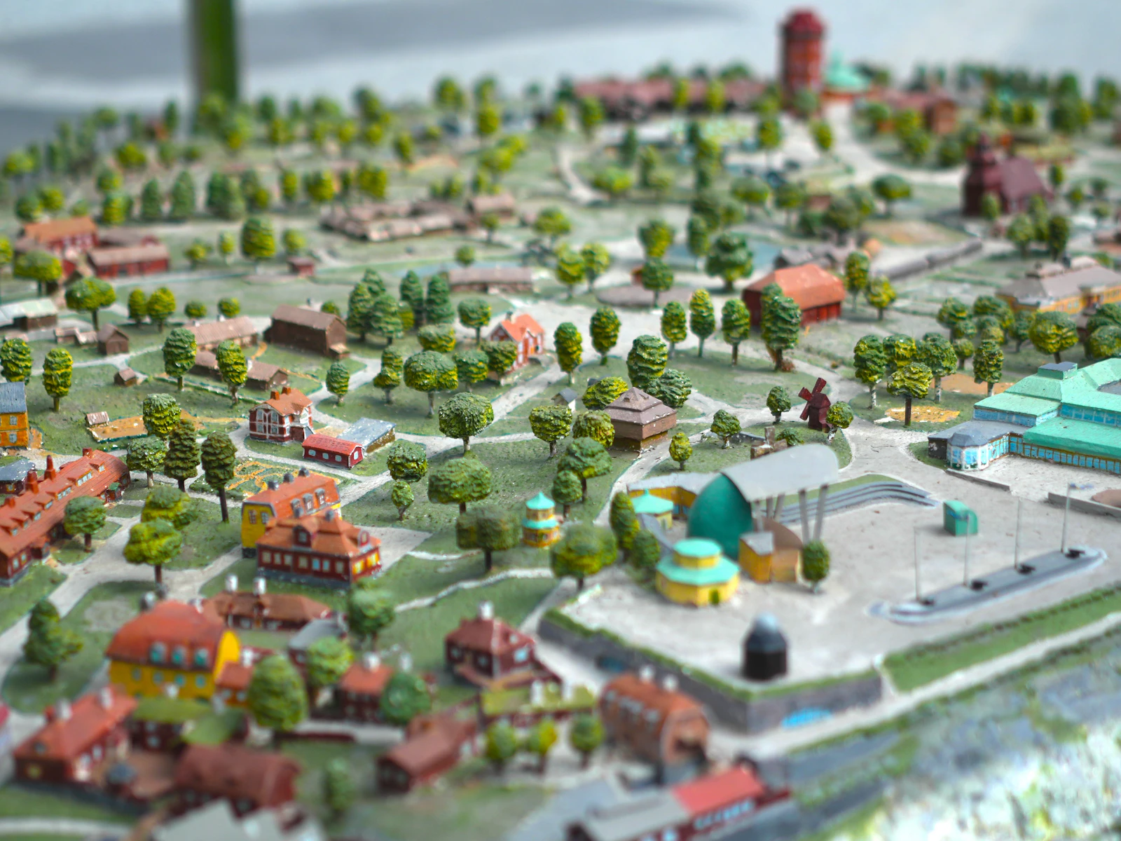 A miniature scale model of a town with small houses and green trees