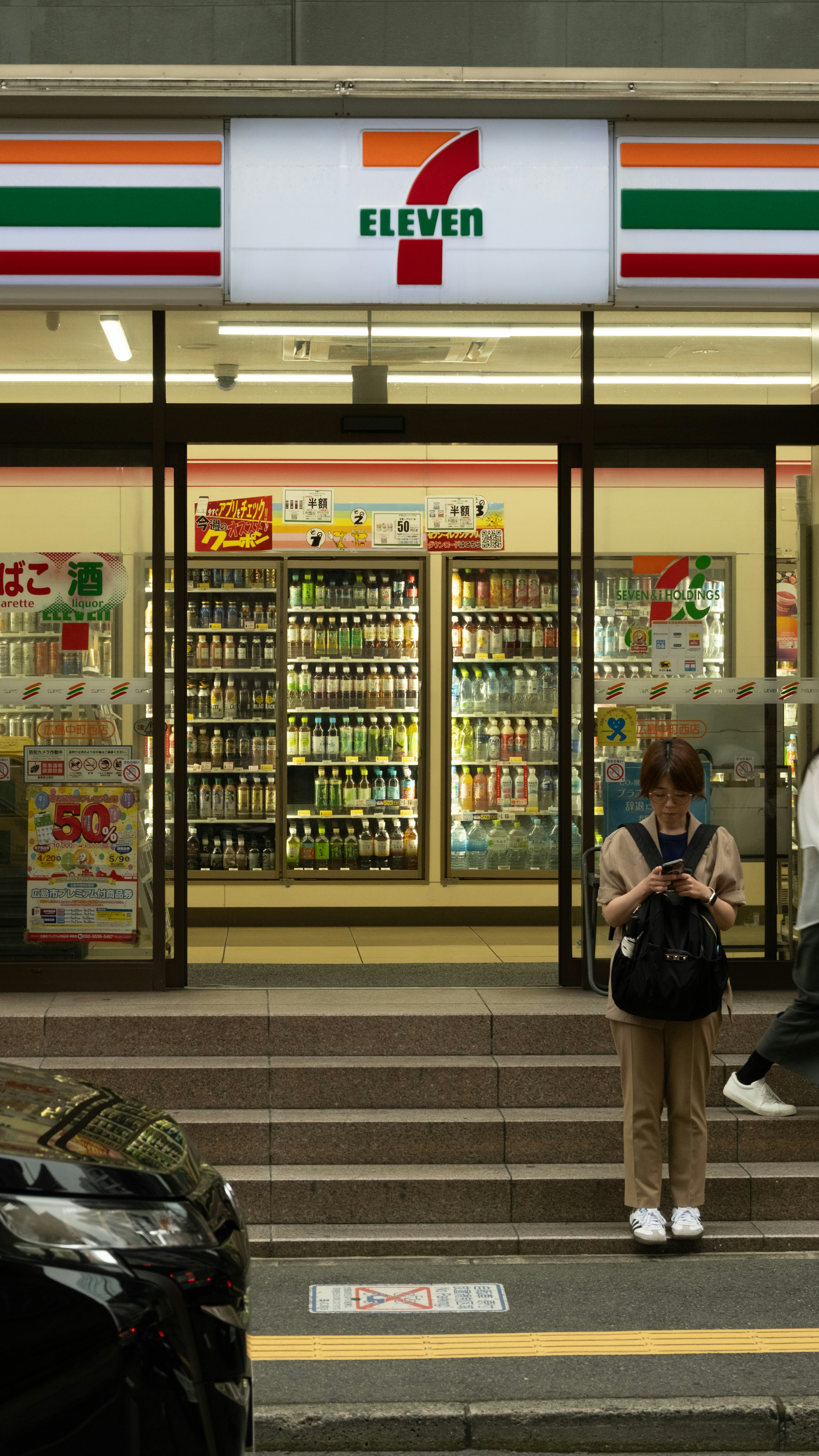 Reading a phone inside a 7-Eleven in Japan